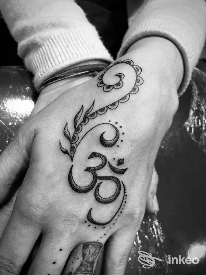 Tatuaggio ornamentale nero sul dorso della mano, con punti e motivi a foglia, realizzato da Ink Klub Tattoo Shop a Ravenna.