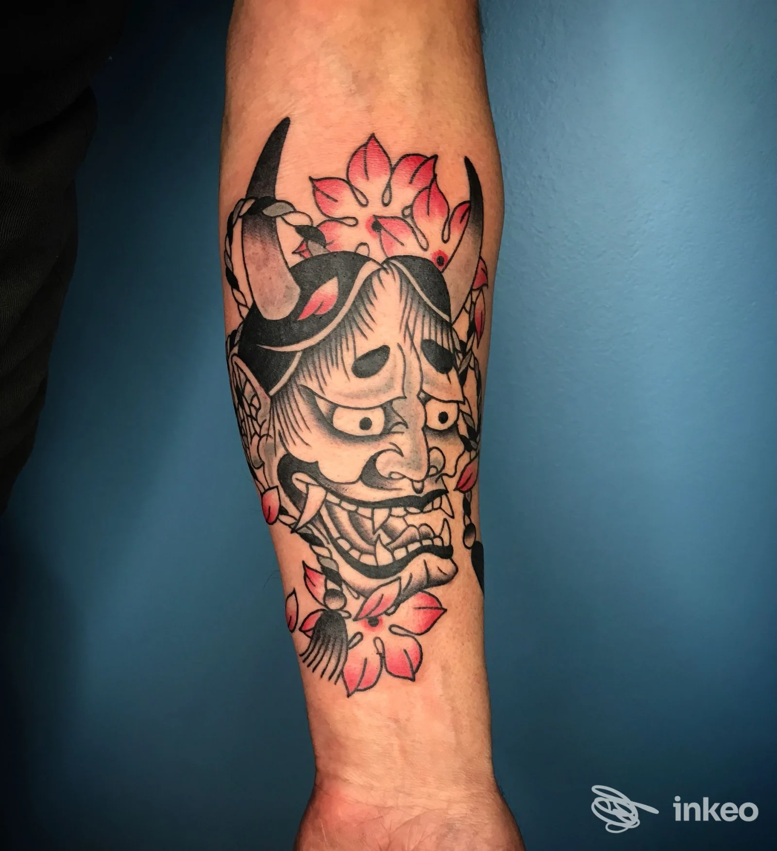 Tatuaggio Hannya sull'avambraccio con linee nere e tocchi rossi, realizzato da Blue Tiger Tattoo shop a Forlì su pelle naturale.