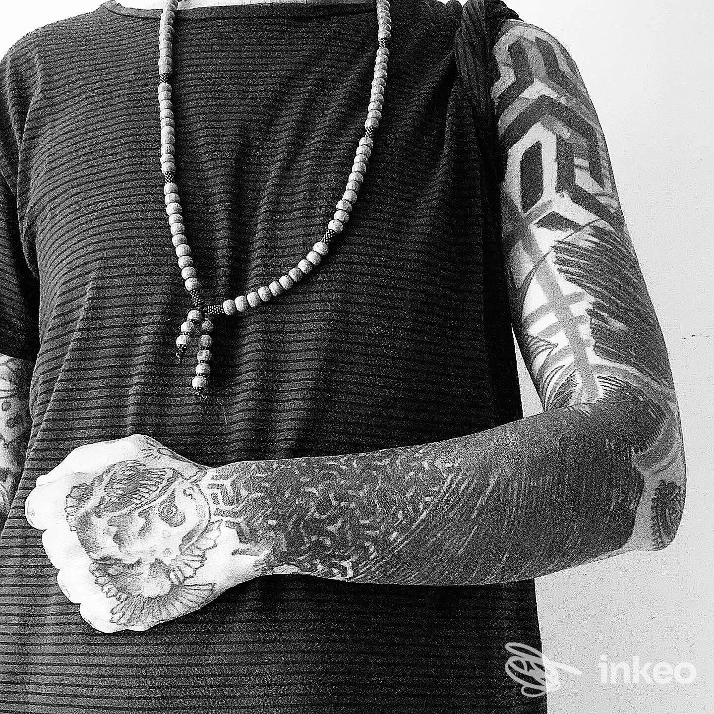 Manica tatuata nera con dettagli floreali sulla mano e motivi geometrici sul braccio, foto per EVOL tattoo studio ad Alessandria.