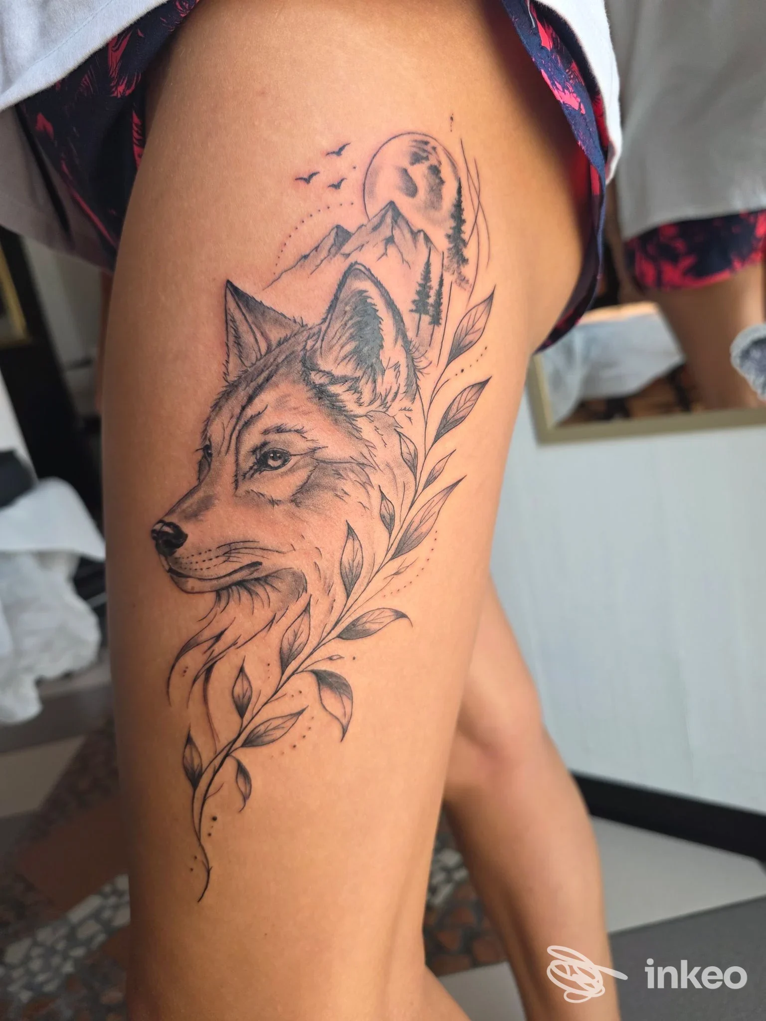 Tatuaggio blackwork di volpe con paesaggio montano sulla coscia, lavoro presentato da More Art Tattoo, Stroppiana.
