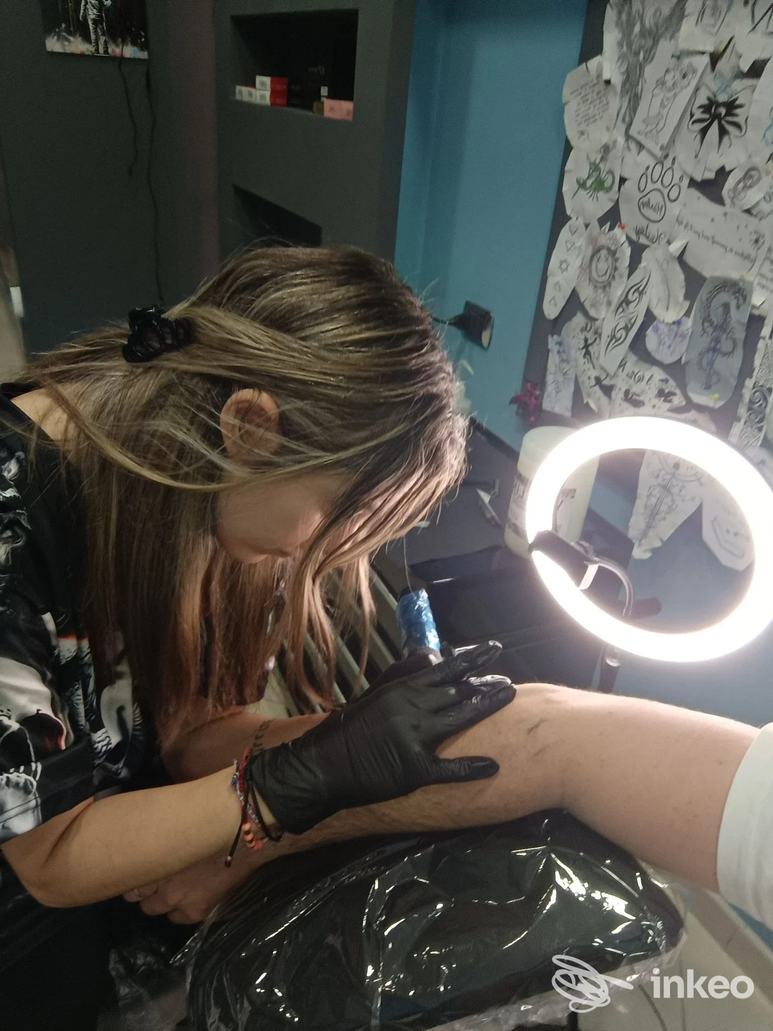 Artista mentre tatua l'avambraccio di un cliente nello studio Siria Art Tattoo a Latiano.