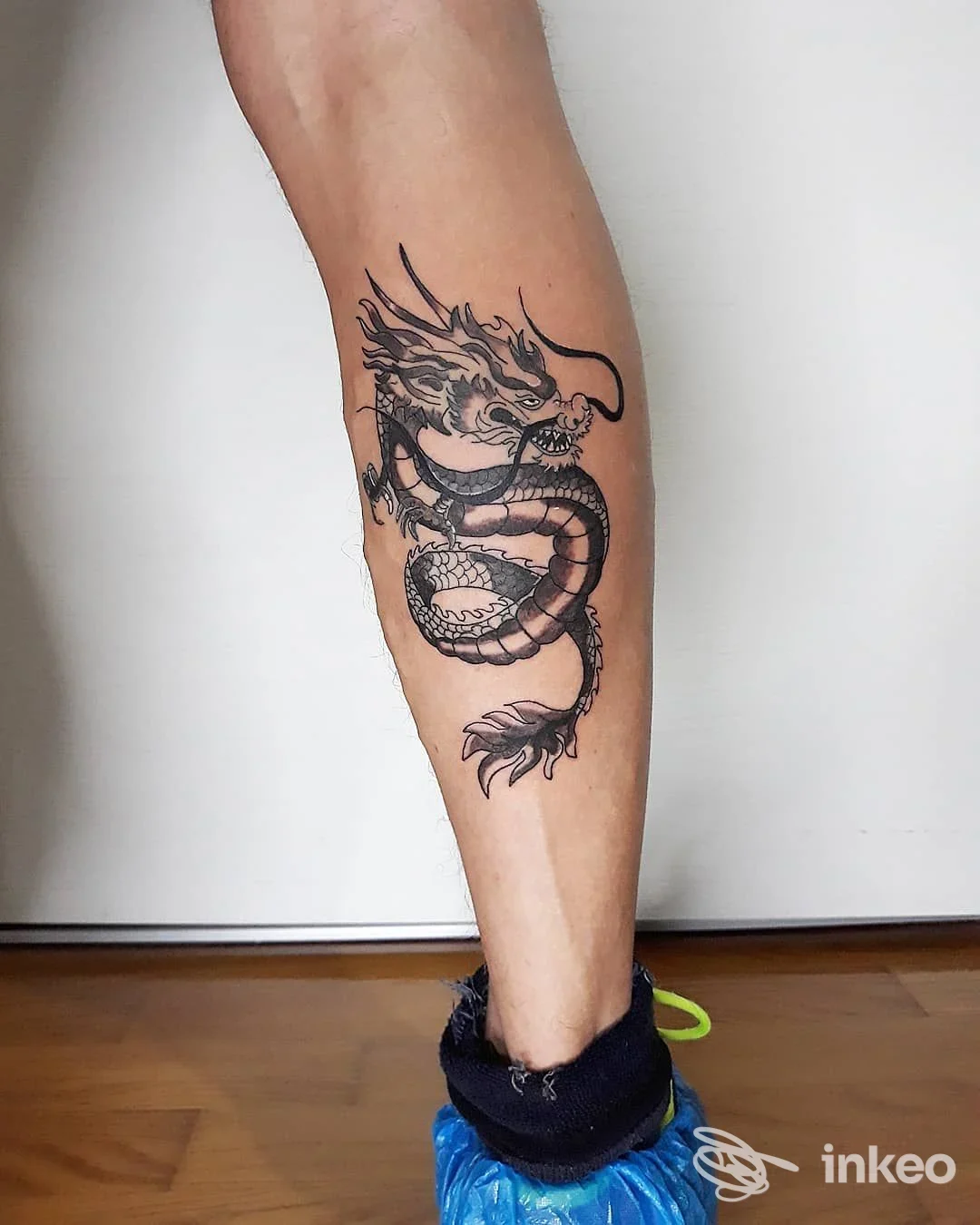 Tatuaggio drago in bianco e nero sul polpaccio, fotografia per Sottopelle Tattoo Studio di Masiero Simone a Mirano.