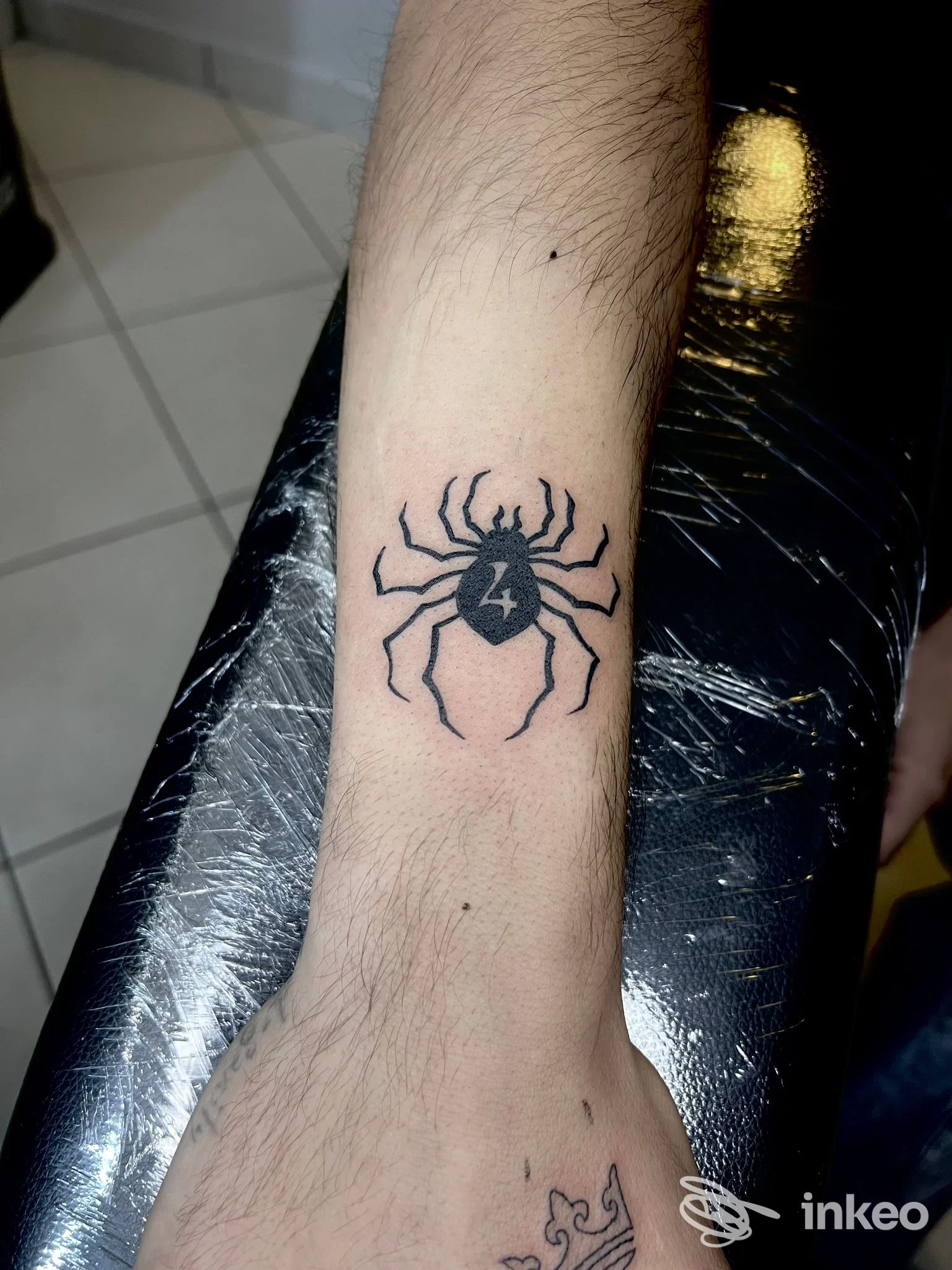 Tatuaggio nero a forma di ragno sull'avambraccio, foto fornita da CN Tattoo Studio a Porto Viro.