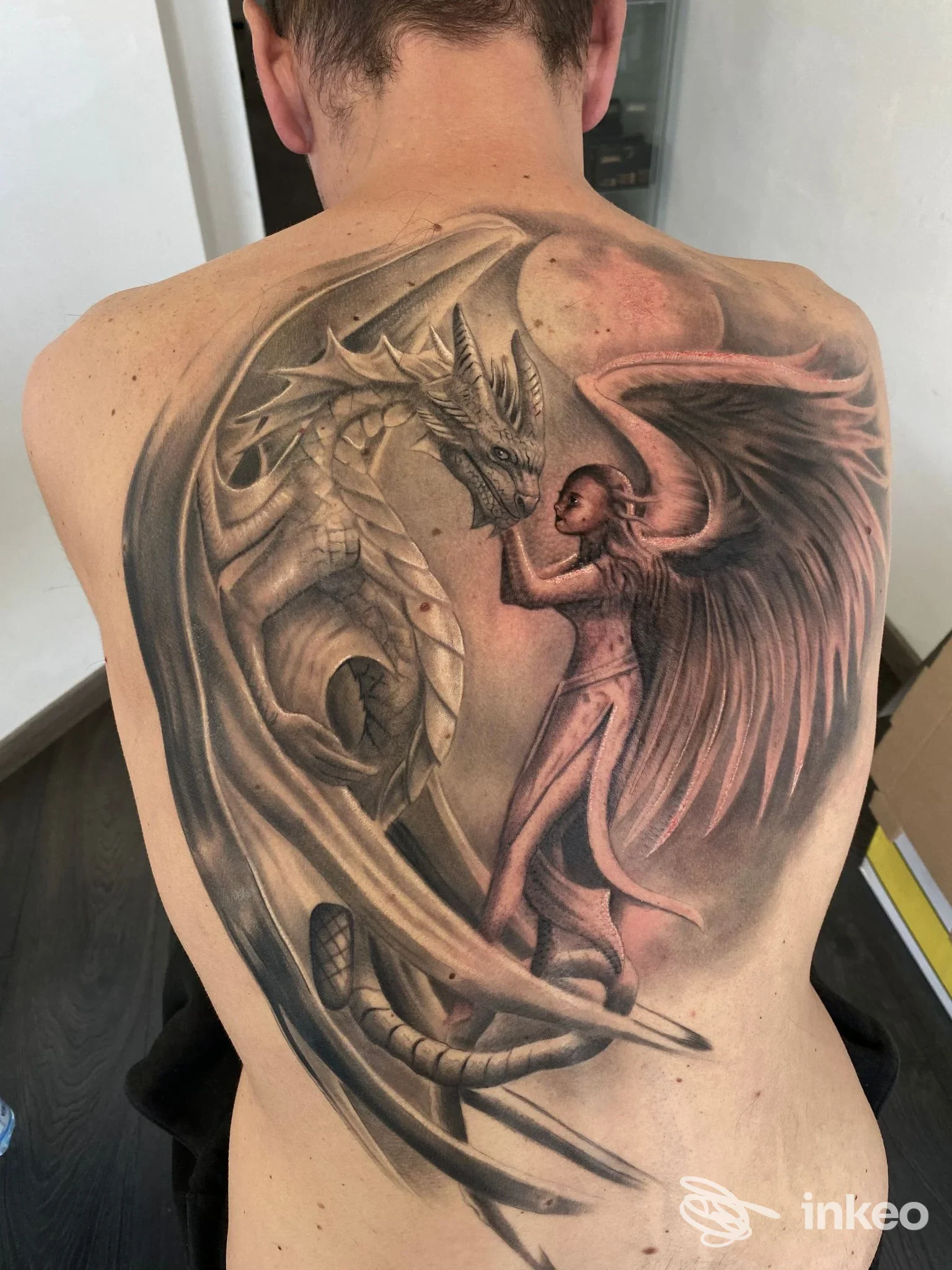 Grande tatuaggio a tutta schiena raffigurante un drago e una figura alata, foto inviata dallo The Rose Tattoo studio, Livorno.