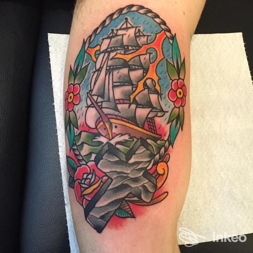 Tatuaggio tradizionale su avambraccio con nave e fiori, foto dello studio Ink Street Tattoo - Glauco Martellini, Orbetello.