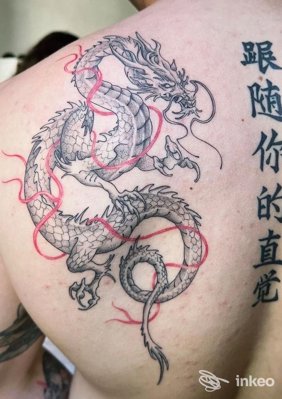 Tatuaggio di drago nero con linee rosse sulla spalla e parte superiore della schiena, foto fornita da Puntonero | Tattoo Studio, Sortino.