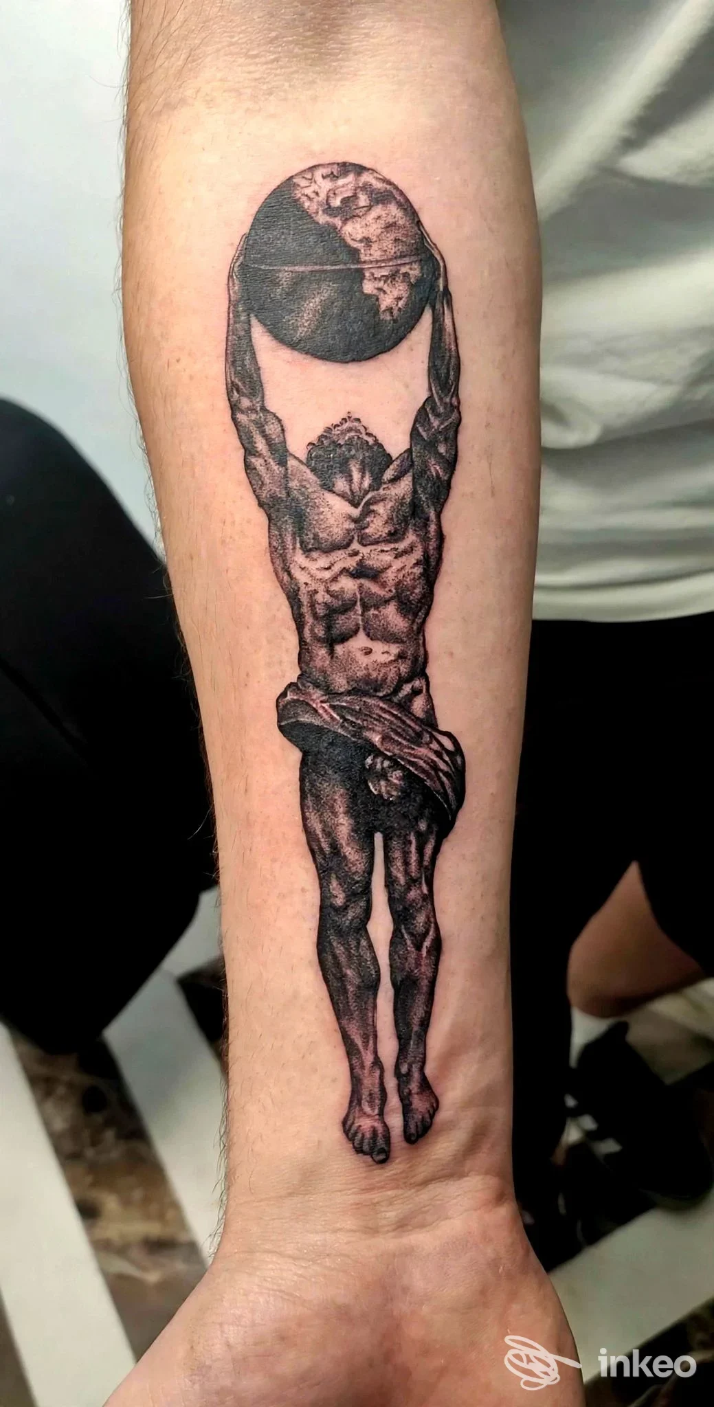 Tatuaggio su avambraccio raffigurante Atlante che regge un globo, Marica Emme Tattoo, Matelica.