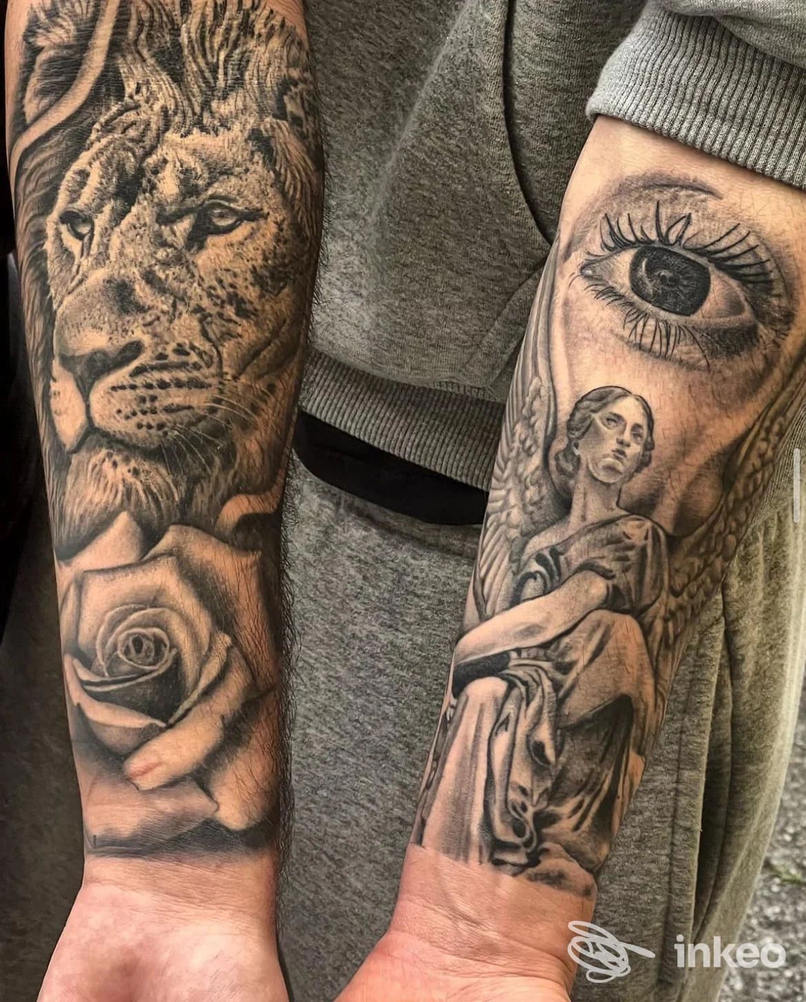 Tattoo sull'avambraccio: leone e rosa sul braccio sinistro, occhio ingigantito e figura femminile sull'altro braccio; tatuaggi ben definiti e dettagli realistici.