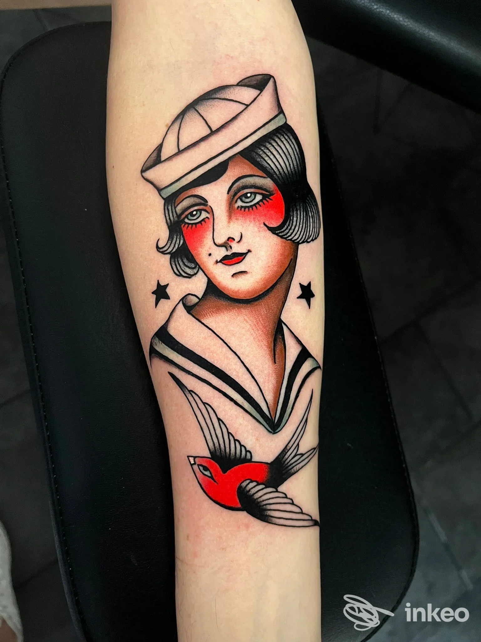 Tatuaggio su avambraccio con ritratto di marinaia e rondine, immagine fornita da Swan Song Tattoo - Studio di tatuaggi - Elba, Capoliveri.