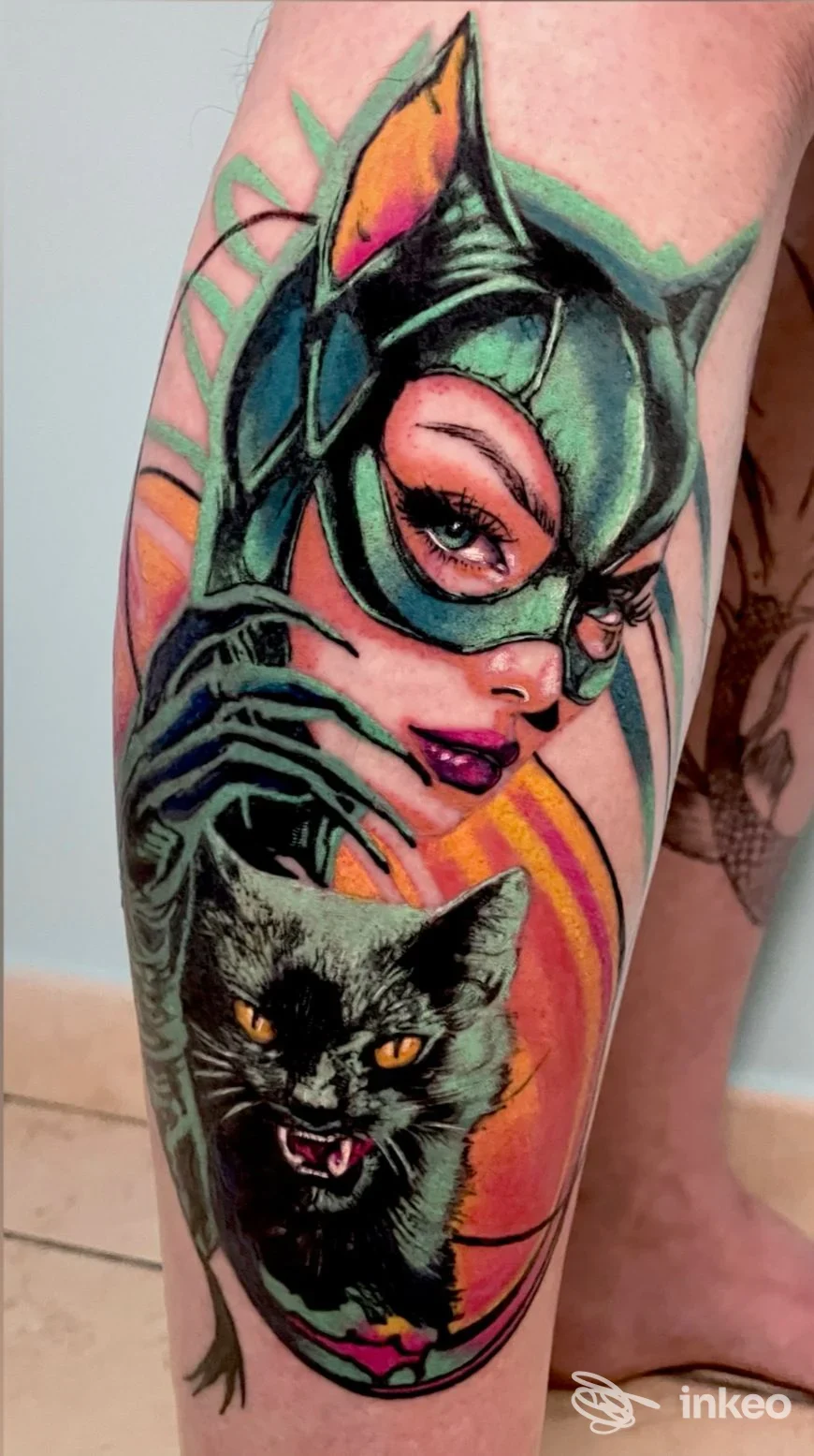 Tatuaggio a colori sul polpaccio con volto femminile mascherato e gatto nero, lavoro fotografato da J ink Tattoo a Polignano a Mare.