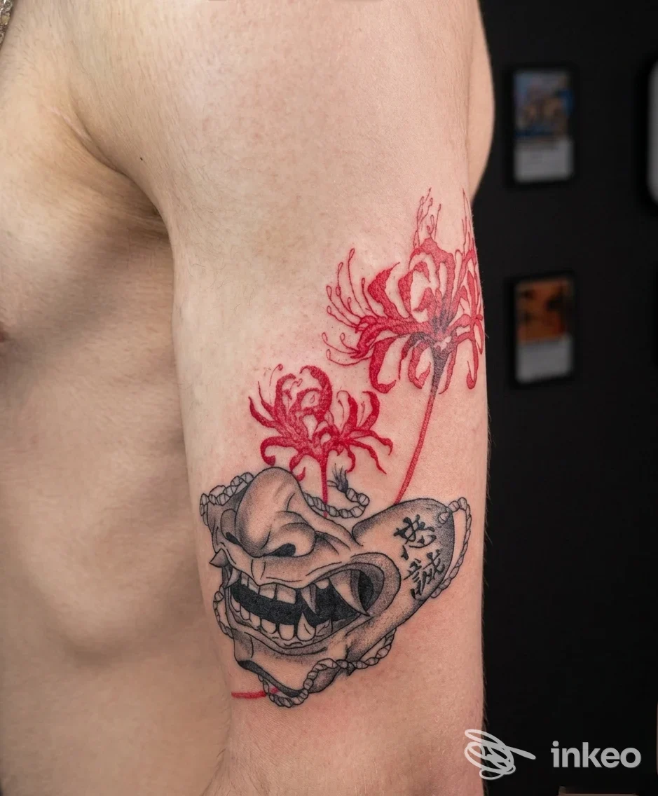 Tatuaggio su braccio con maschera stilizzata in nero e fiori rossi, realizzato da The Elden Ink Tattoo a Cavallino-Treporti.