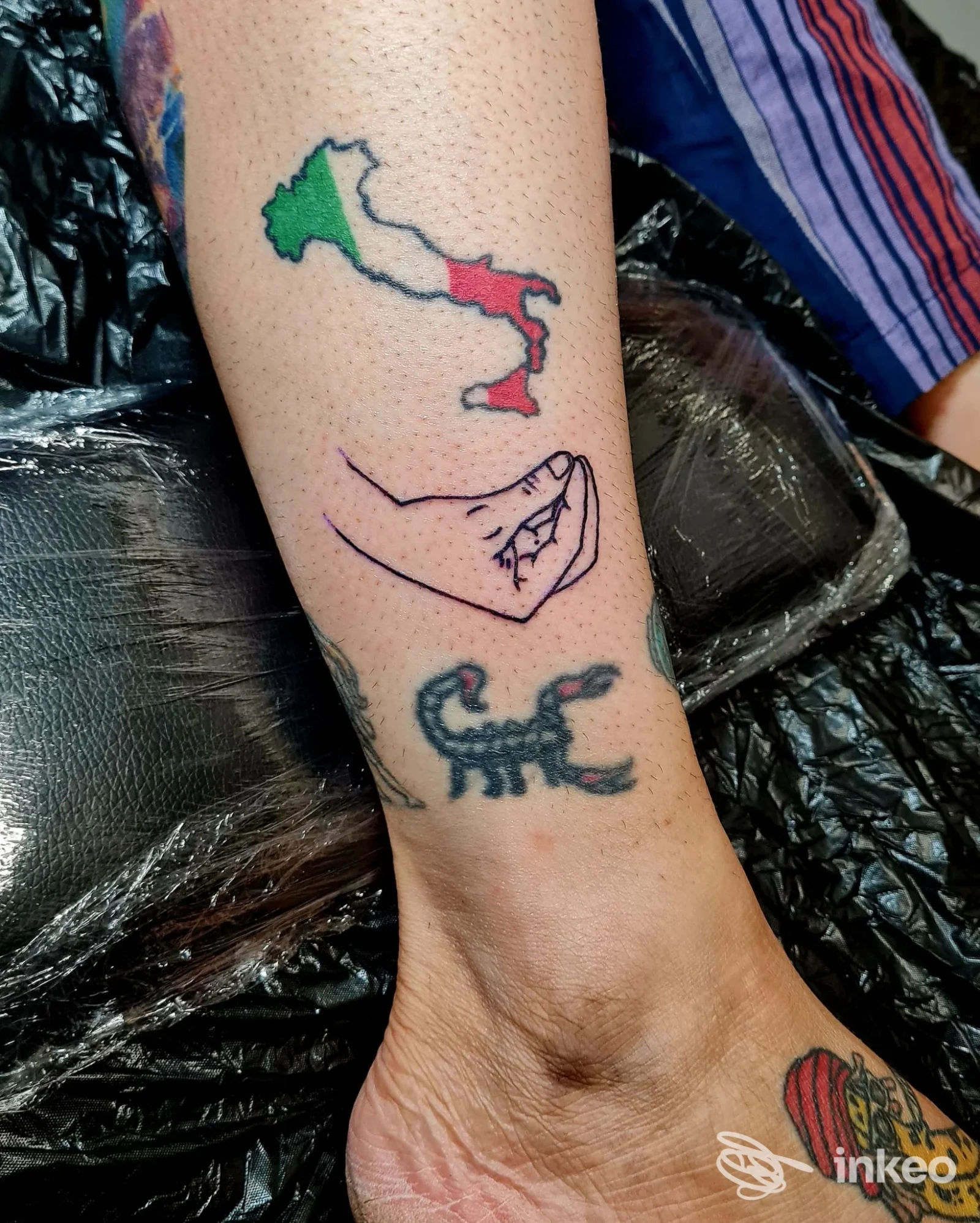 Tatuaggi su polpaccio e caviglia fotografati presso Florence Tattoo Studio, Firenze: Italia tricolore, mano stilizzata e scorpione.