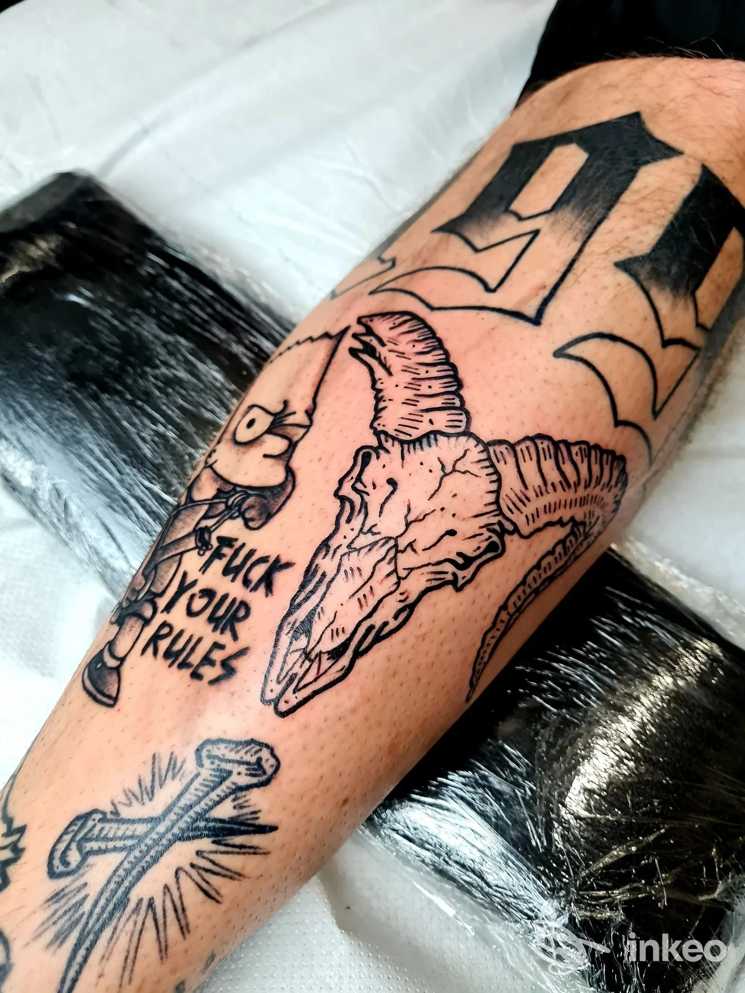 Primo piano di un avambraccio tatuato con cranio di capra, croce e scritta; immagine fornita da Florence Tattoo Studio, Firenze.