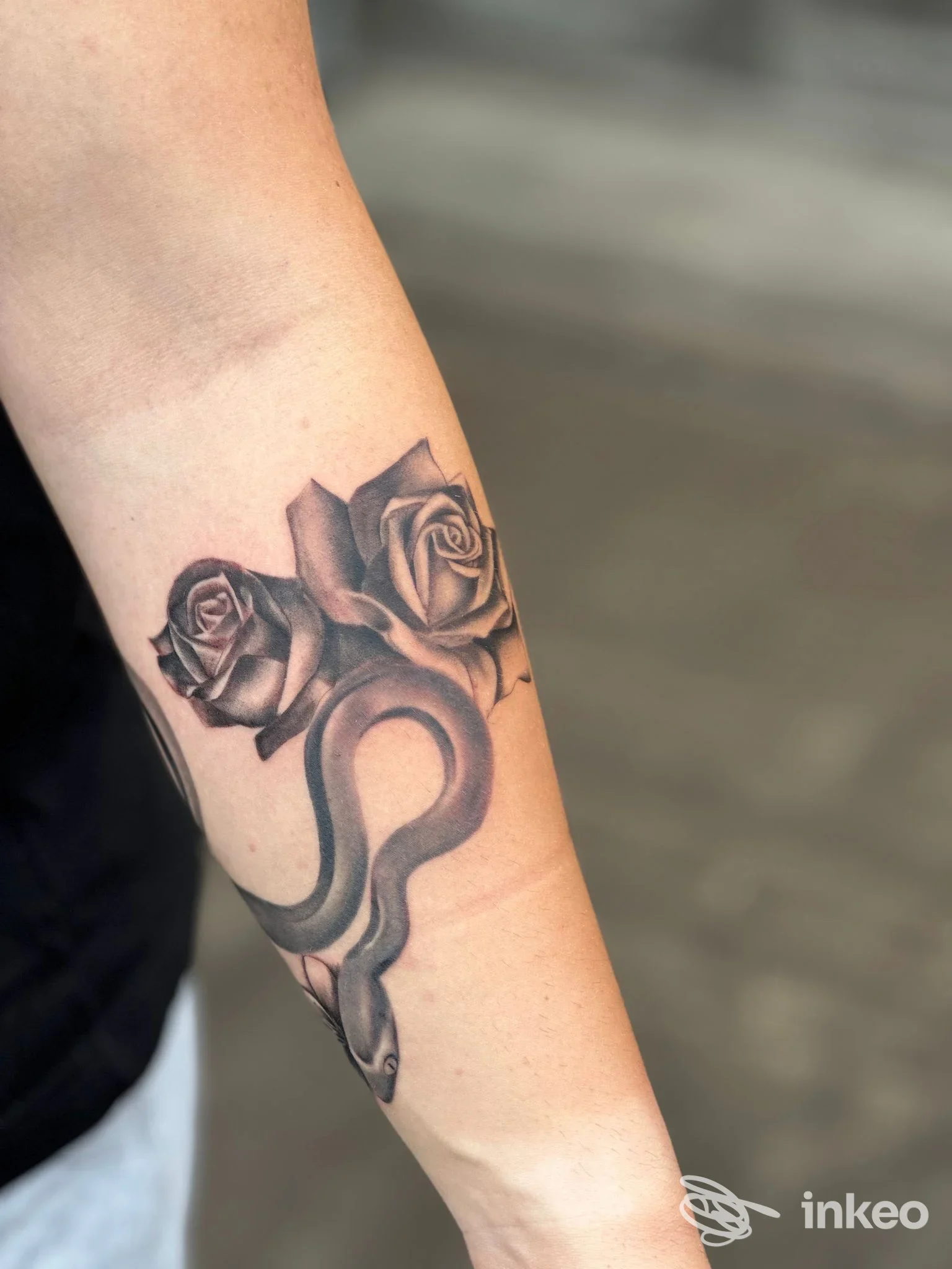 Tatuaggio in bianco e nero con rose e serpente sull'avambraccio, foto di Chibi Moon Studio Tattoo a Torre Pellice.