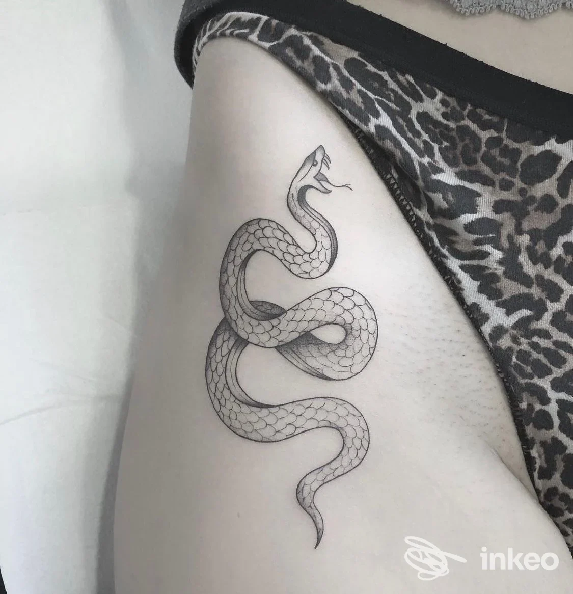 Tattoo realistico di serpente lungo sulla pelle, linee pulite e dettagli a squame, visibile sul fianco/coscia. Studio Inkdust Tattoo Studio.