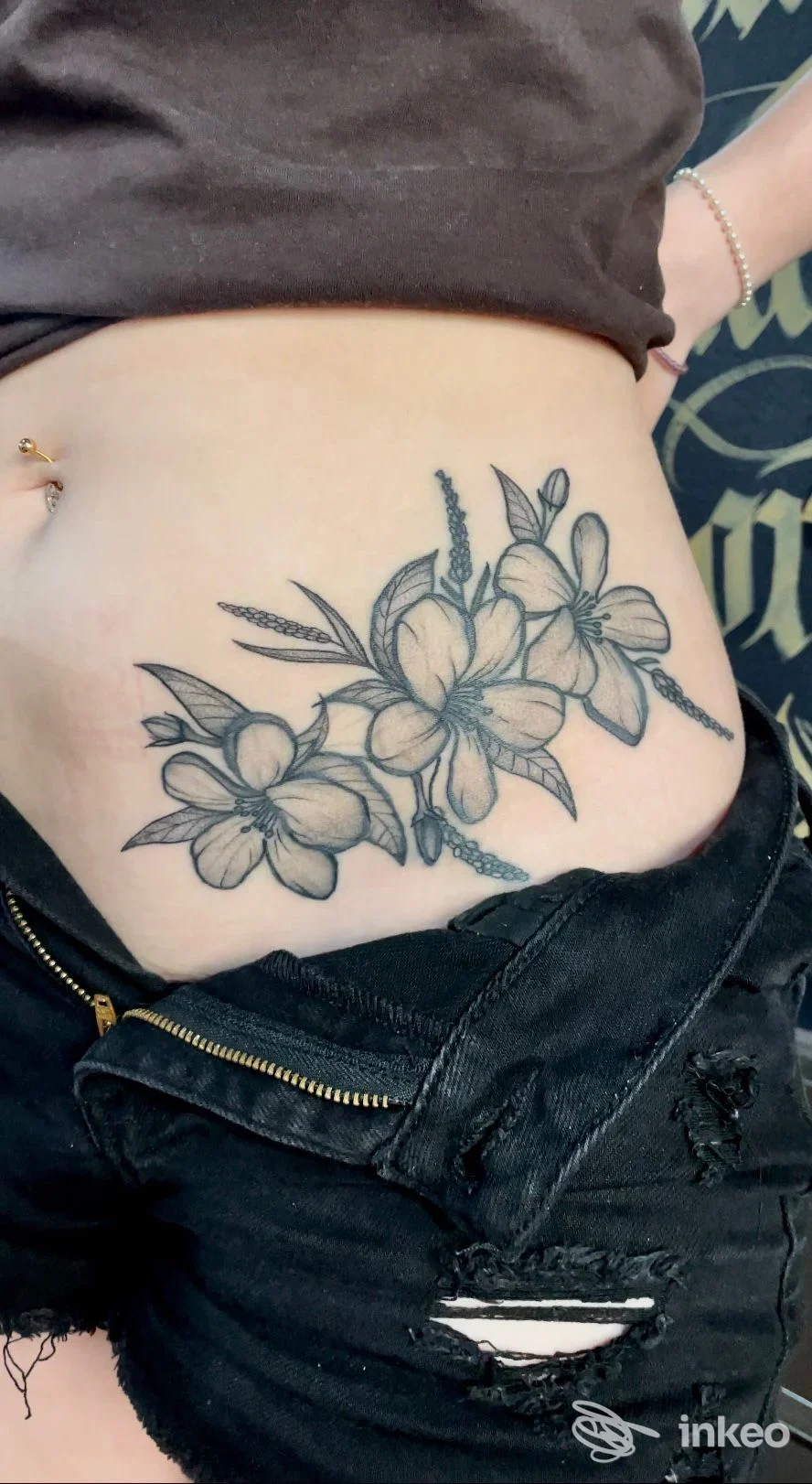 Tatuaggio floreale in nero/grigio sul fianco addominale, foto inviata da Tuscan Tattoo Studio, Prato.