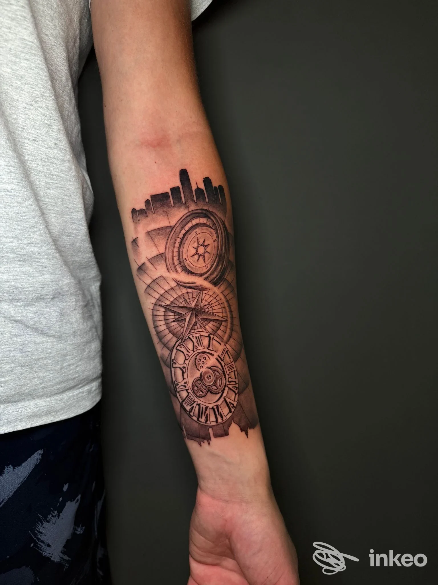 Tatuaggio in bianco e nero su avambraccio con skyline e ingranaggi, foto fornita da KINEKO TATTOO, Firenze.