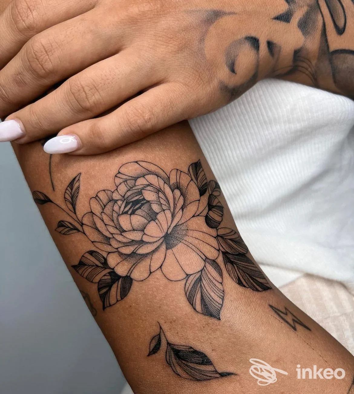 Tatuaggio floreale nero su avambraccio interno, fotografia realizzata per InkPression Tattoo Studio a Torino.