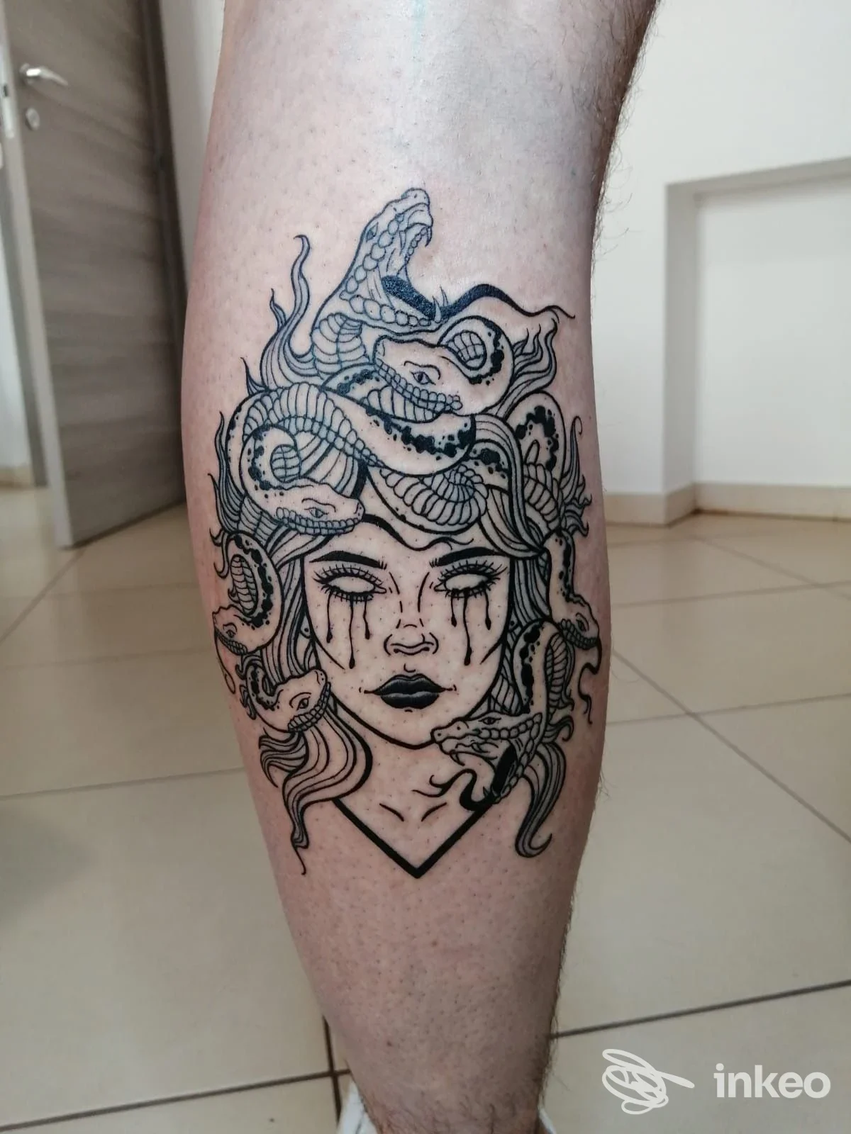 Tatuaggio in bianco e nero tipo Medusa sul polpaccio, fotografia di Dama Thesign Tattoo a Rosolini.