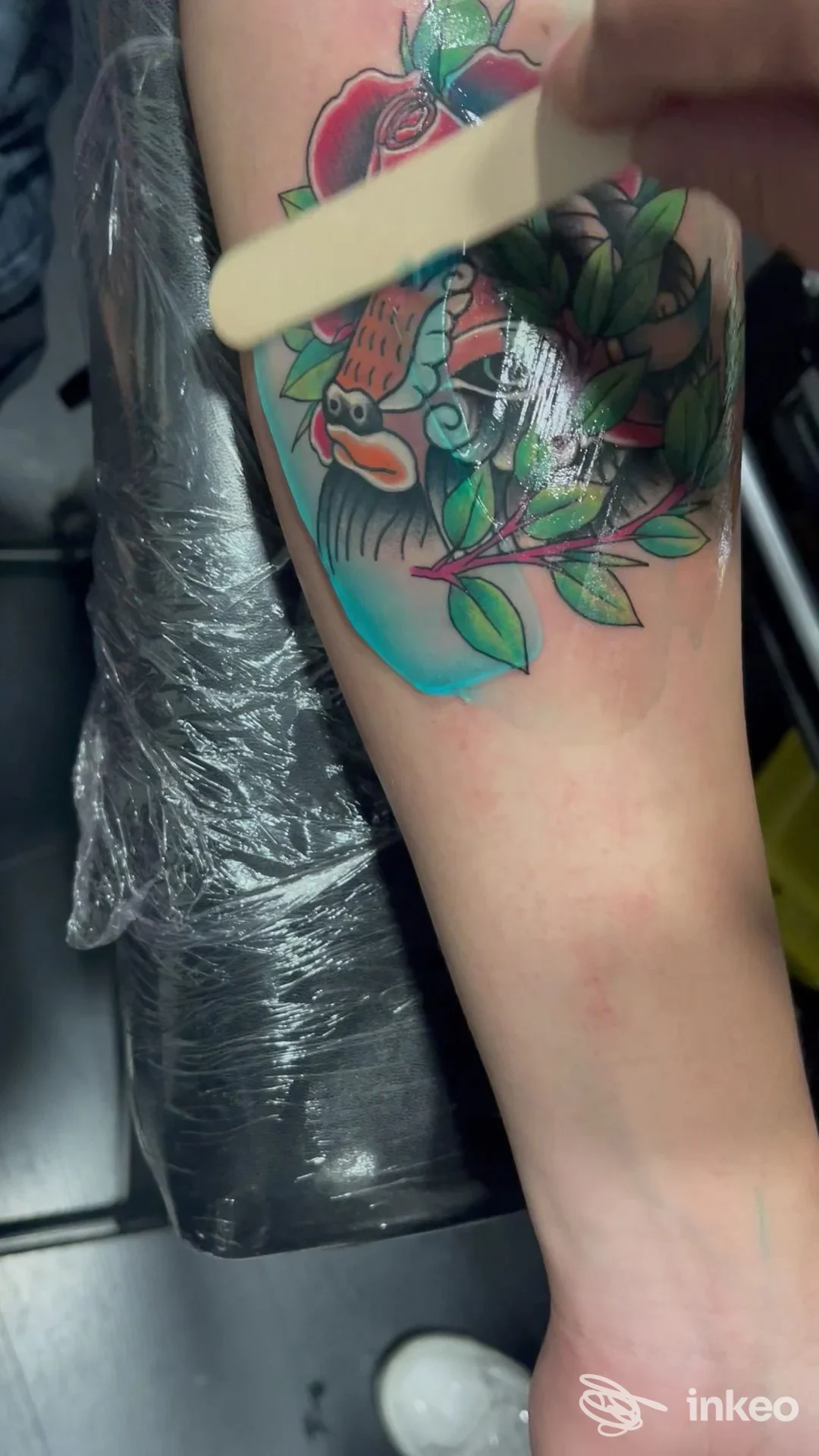 Primo piano di un tatuaggio colorato con un pesce koi e foglie su avambraccio, fotografia scattata nello studio Firenze Ink Tattoo Studio a Firenze.