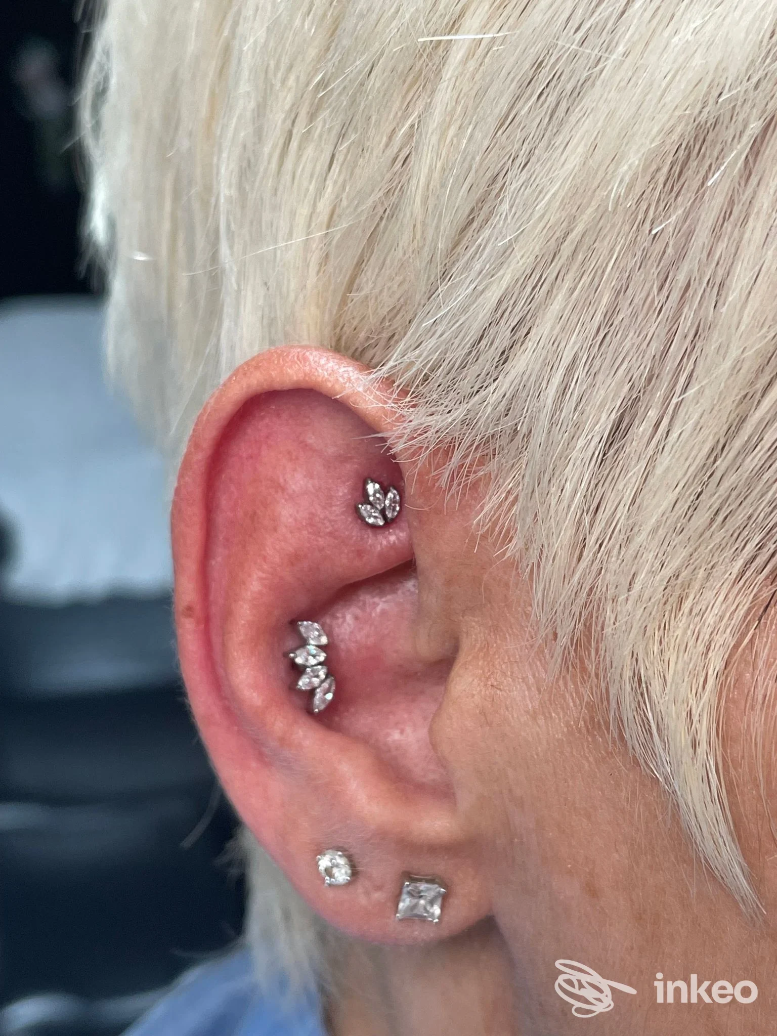 Primo piano di un orecchio con più piercing in metallo lucido, foto fornita da Hell's piercings a Piossasco.