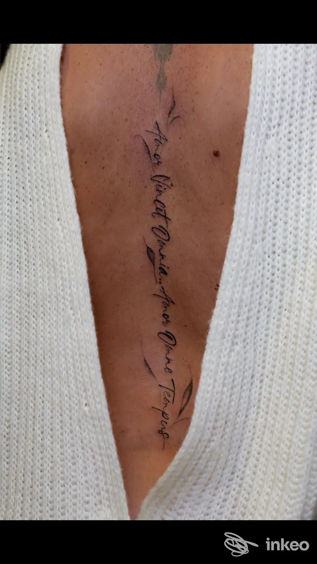 Tatuaggio calligrafico verticale al centro del petto con piccole foglie decorative, fotografia Paolina Modena Beauty Tattoo, Bastiglia.