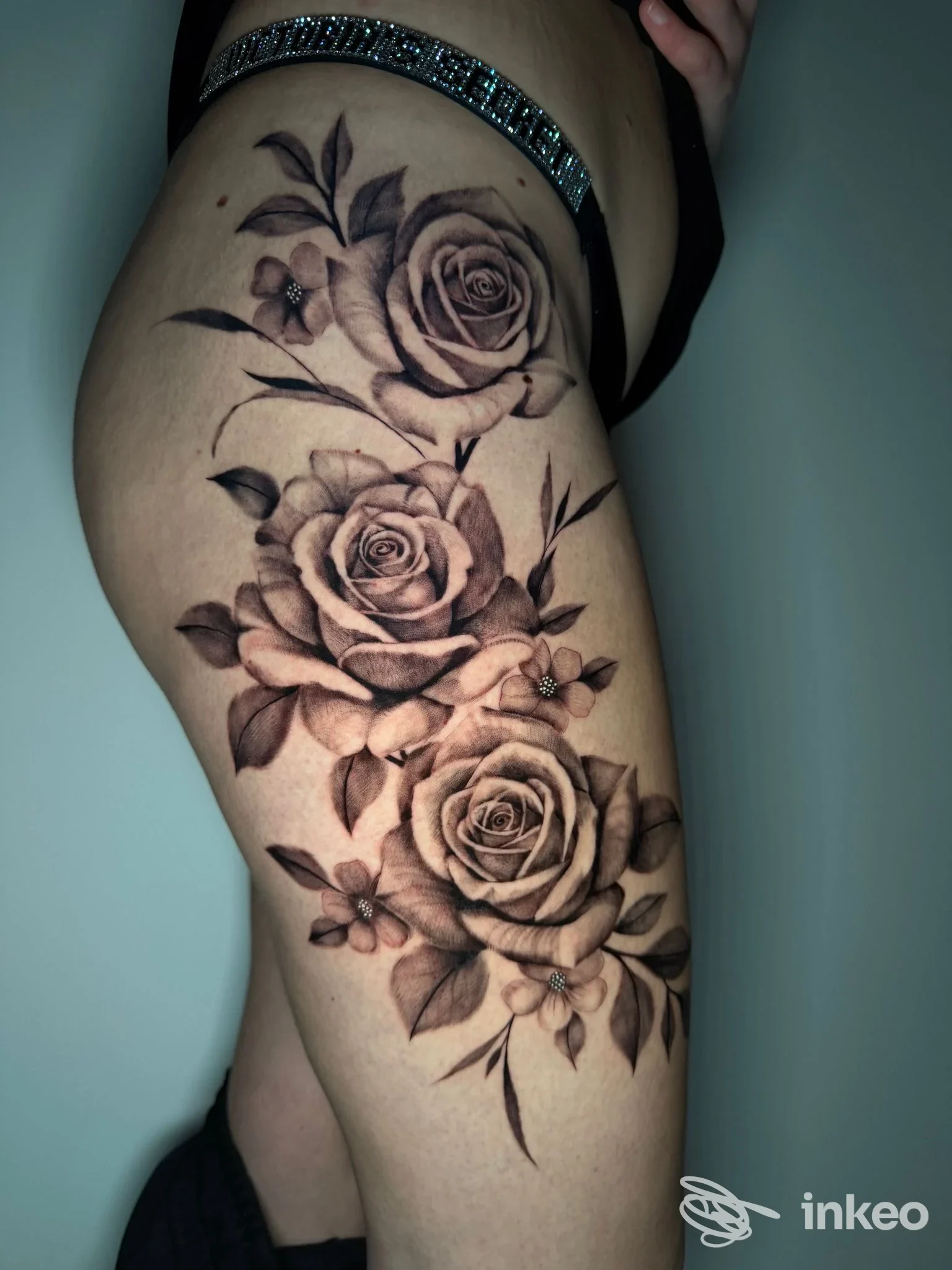 Tatuaggio realistico in nero e grigio di tre rose sulla coscia, fotografato per Ego Noir Tattoo Studio, Chioggia.