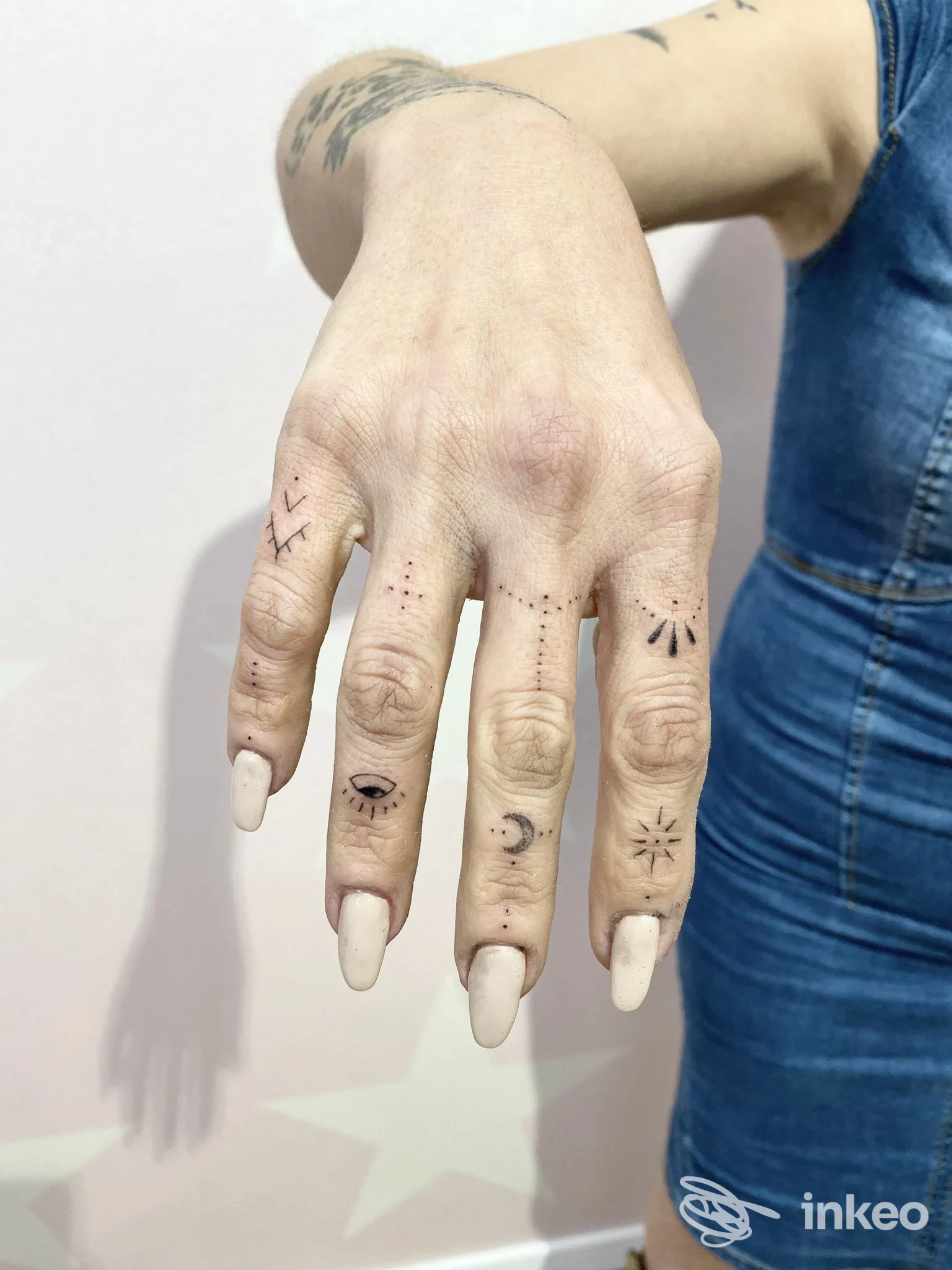 Primo piano di una mano con piccoli tatuaggi sulle dita, foto fornita da Samy Tattoo Studio, San Lazzaro di Savena.