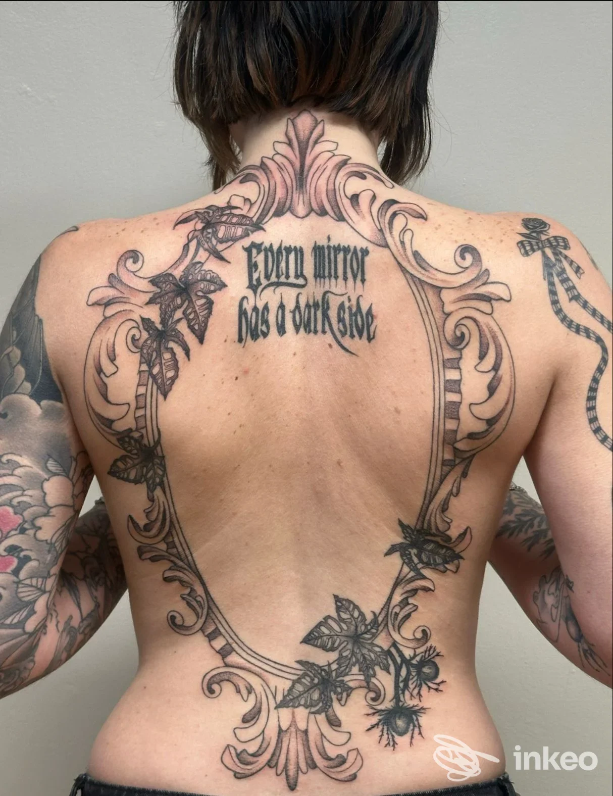 Lavoro su schiena con grande cornice ornamentale nera e scritta centrale, Kora Tattoo Studio, Fossano.