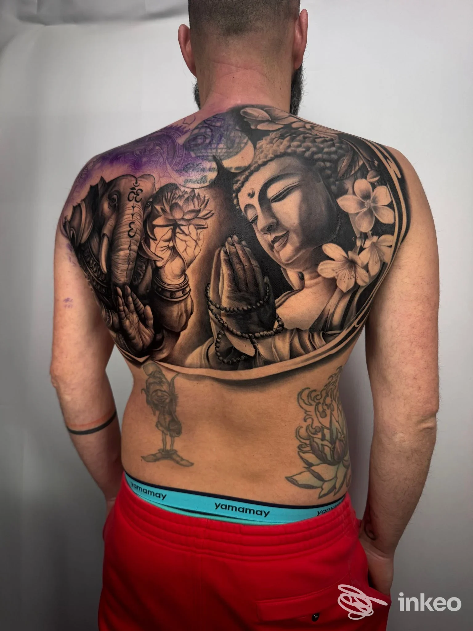 Ampio tatuaggio black & grey su tutta la schiena con figura di Buddha e fiori, fotografia inviata da La Rosa Nera Tattoo e Piercing, Calenzano.