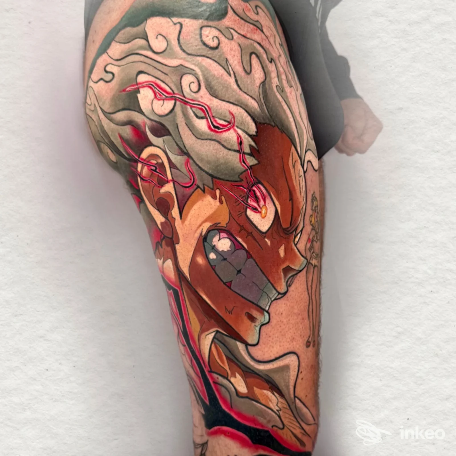 Grande tatuaggio colorato su braccio con volto stilizzato, foto fornita da La Rosa Nera Tattoo e Piercing, Calenzano.
