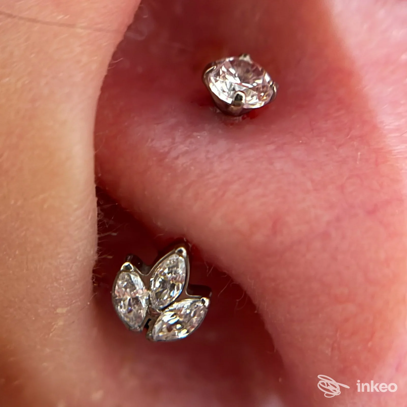 Primo piano di due piercing al lobo con gioielli cristallo, fotografia realizzata da Lenya Piercing Studio a Lugo.