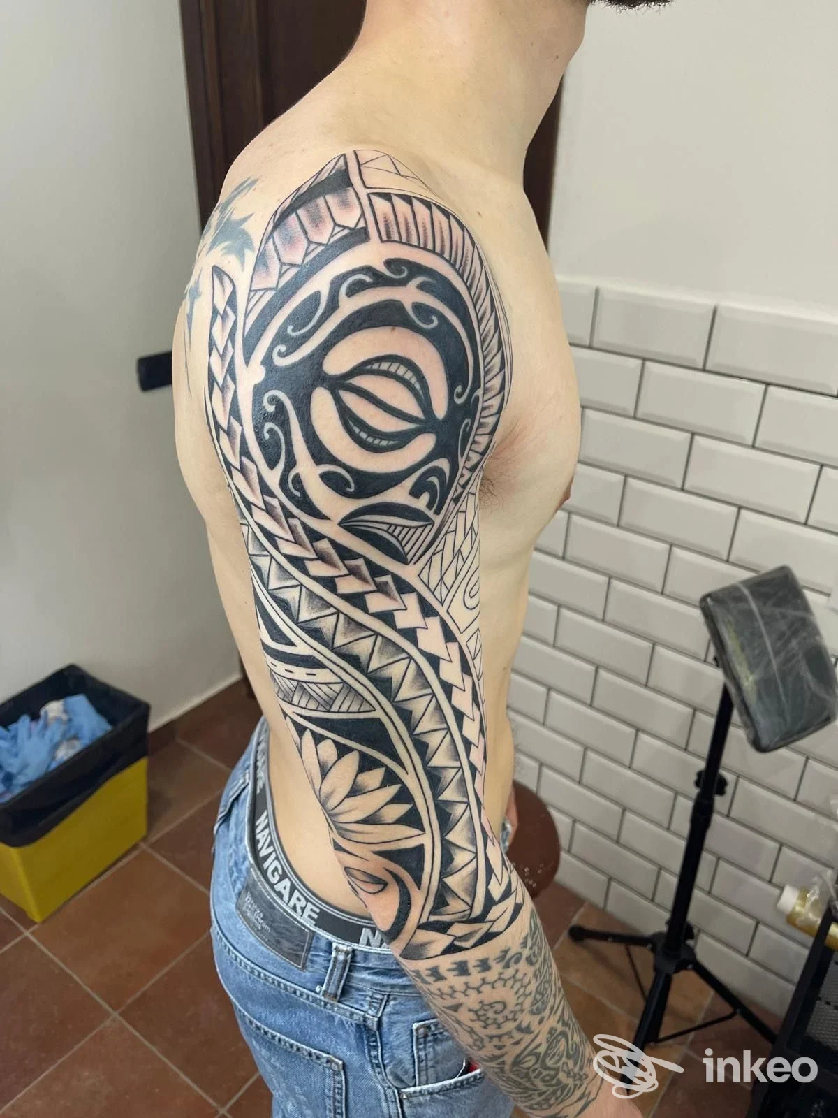Tatuaggio tribale che copre spalla e tutto il braccio su cliente fotografato nello studio Slow Horse tattoo club, Ferrara.