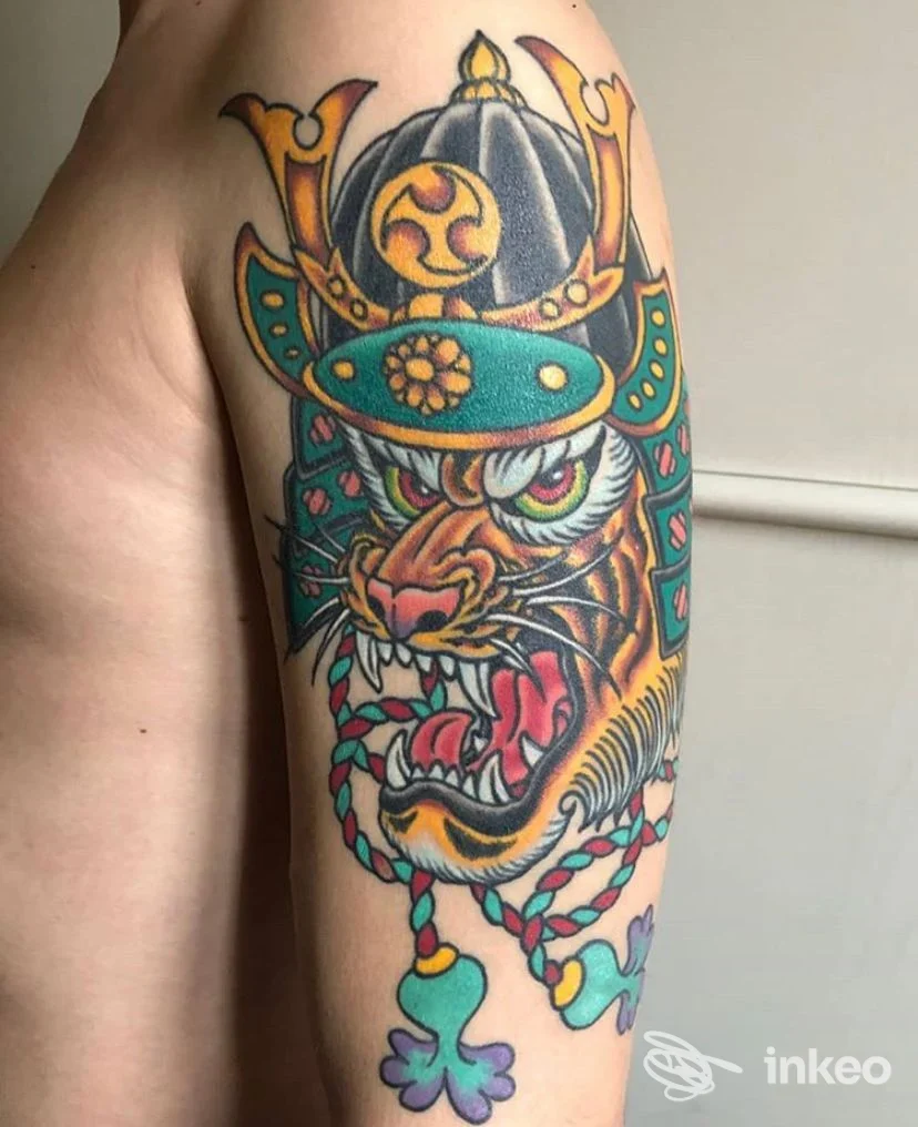 Tatuaggio colorato a tema samurai con testa di tigre sul braccio, fotografato per Pace e Inchiostro a Ferrara.