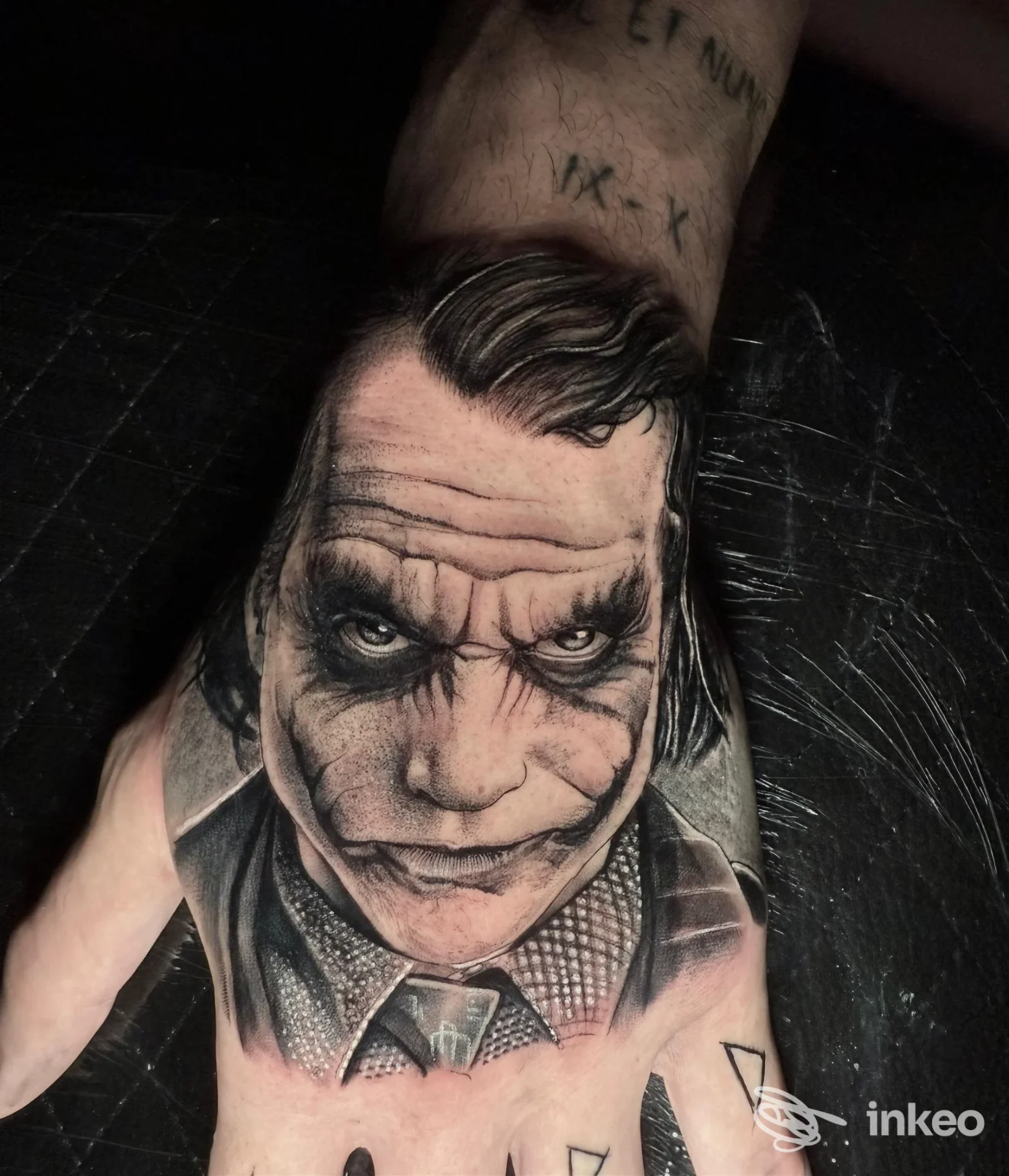 Tatuaggio realistico del volto del Joker sul dorso della mano, opera realizzata da The Family ink a Brindisi.