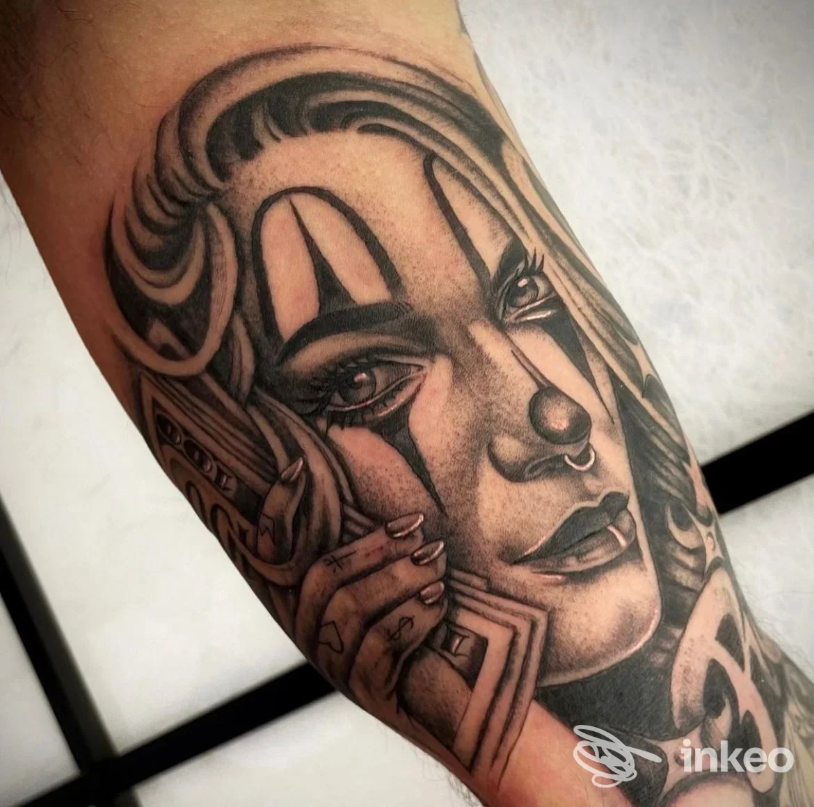 Tatuaggio realistico in bianco e nero su avambraccio con volto stilizzato e dettagli curati, foto fornita da HOMEBODY Tattoo Lab, Bologna.