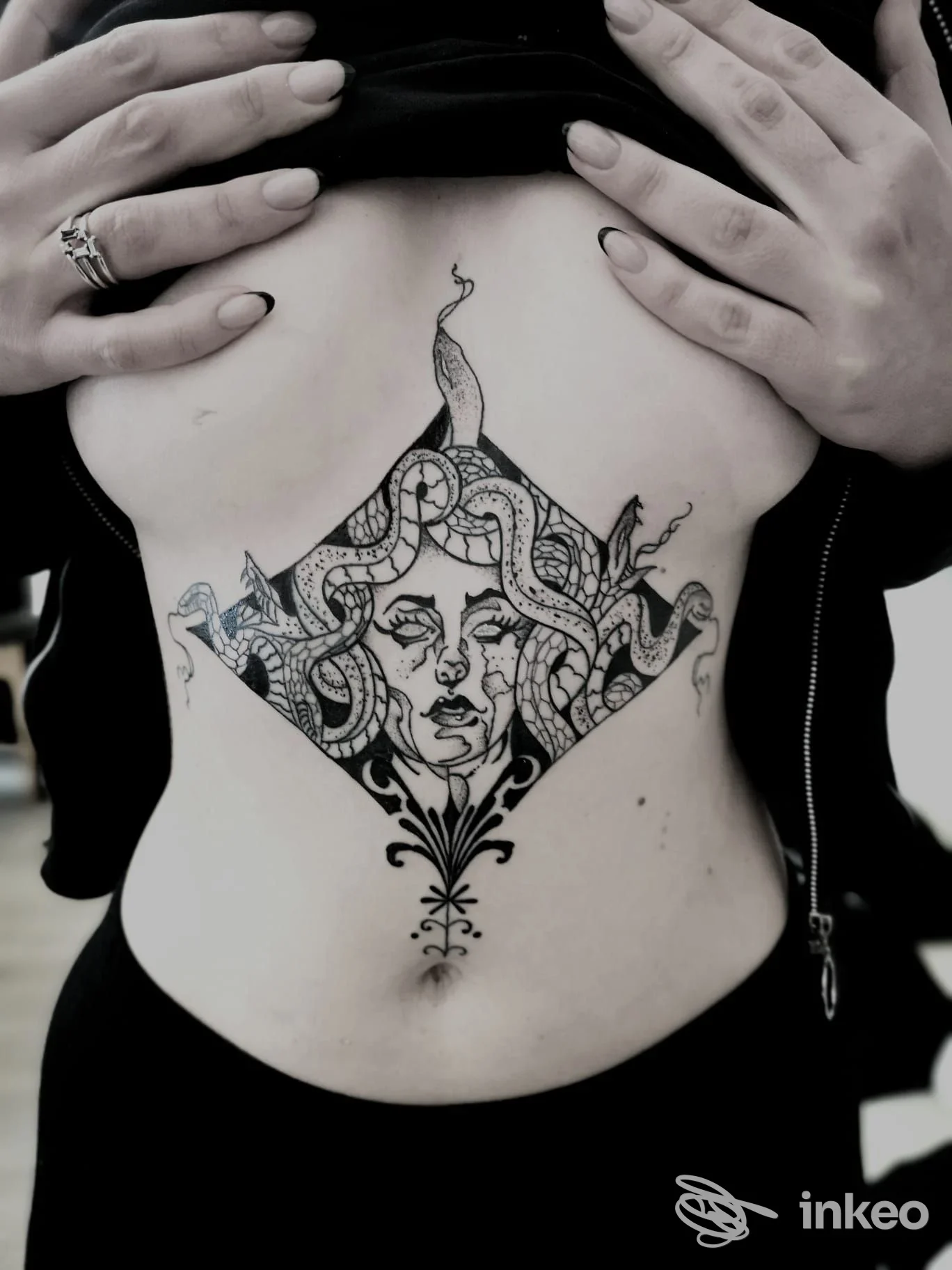 Tatuaggio blackwork ornamentale sullo sterno/ombelico, fotografia dello studio Alley Doll a Faenza.