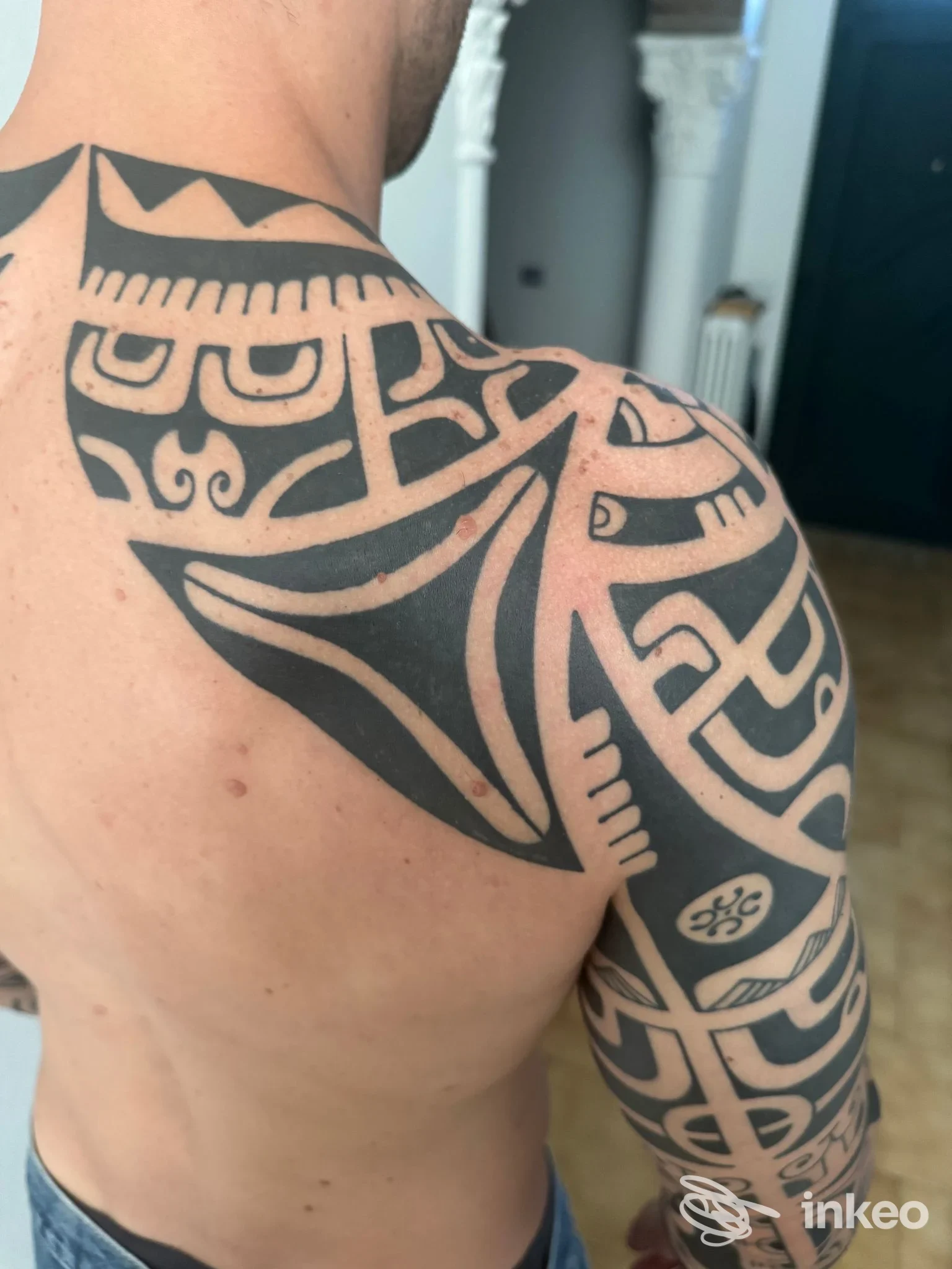 Ampio tatuaggio tribale nero su spalla, braccio e parte superiore della schiena, foto inviata da TRIBAL TATAU a Formigine.