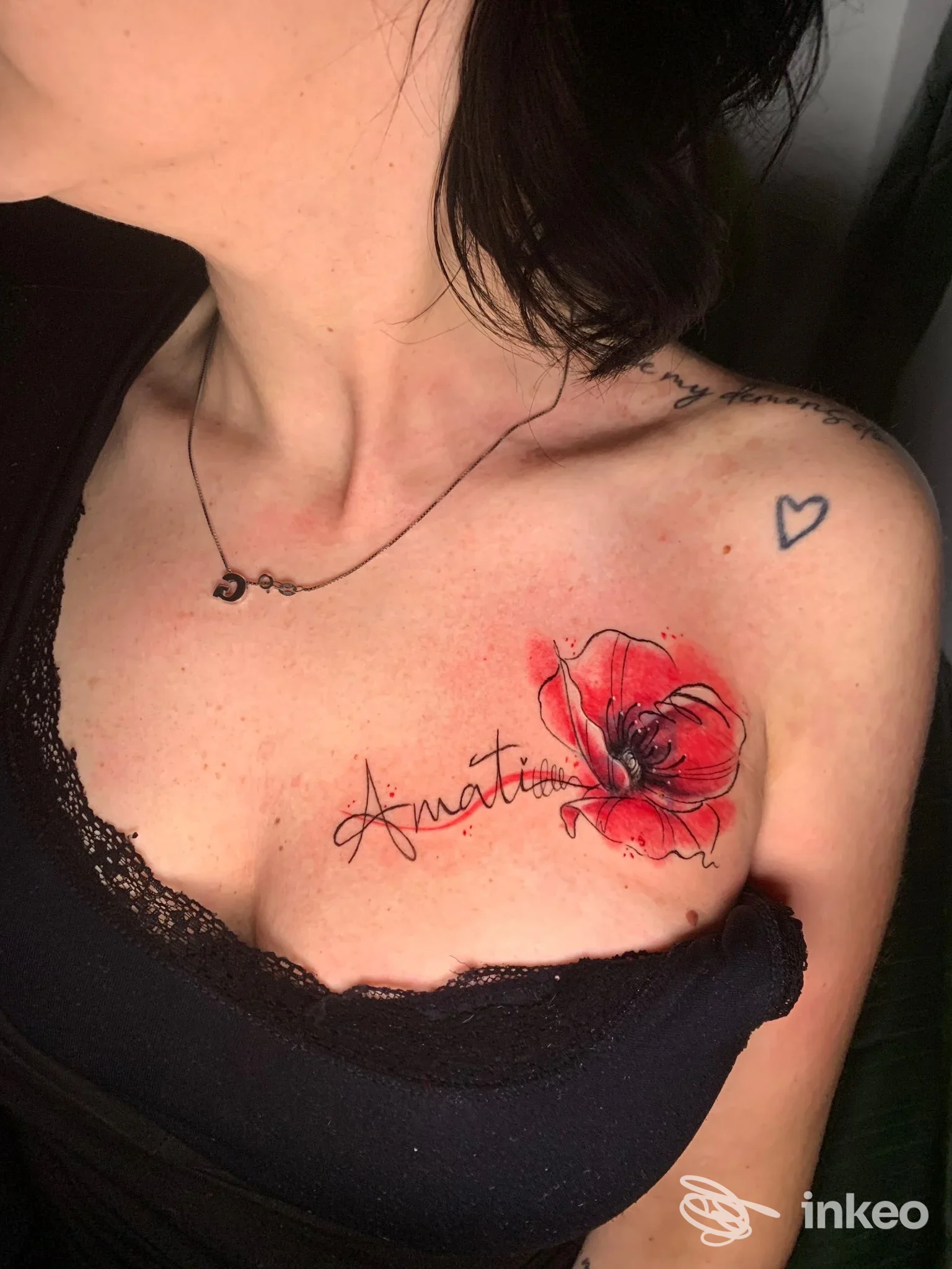 Tatuaggio a fiore rosso con scritta sul décolleté, scatto sul corpo realizzato da La Bea Tattoo Studio a Cesena.