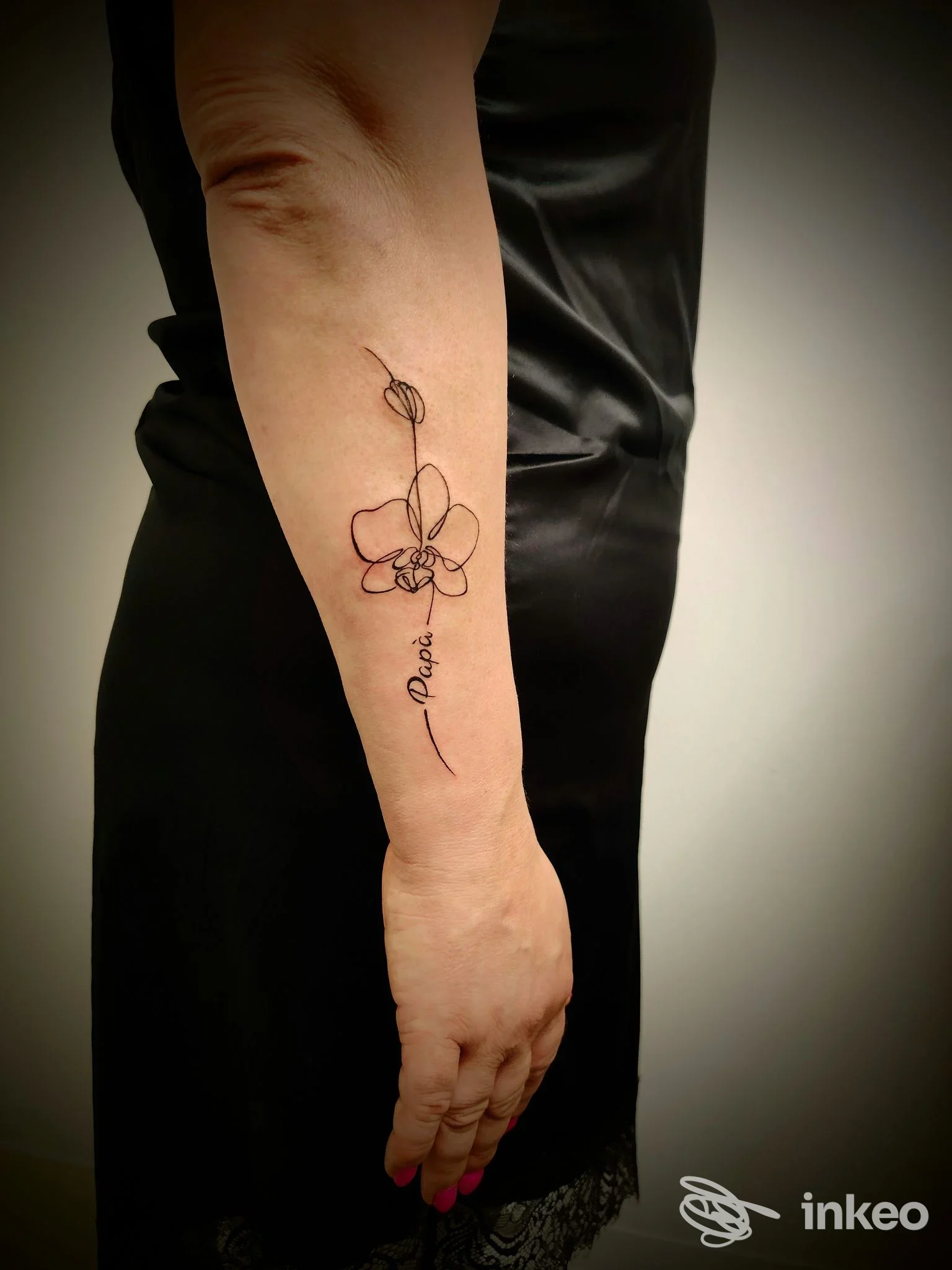 Tatuaggio minimal lineare a forma di orchidea sull'avambraccio realizzato da Velvet Drop Tattoo Boutique, Trevignano.