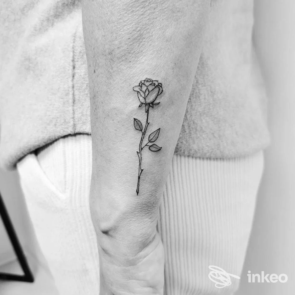Tatuaggio minimal di una rosa nera sull'avambraccio interno, eseguito da Velvet Drop Tattoo Boutique a Trevignano.
