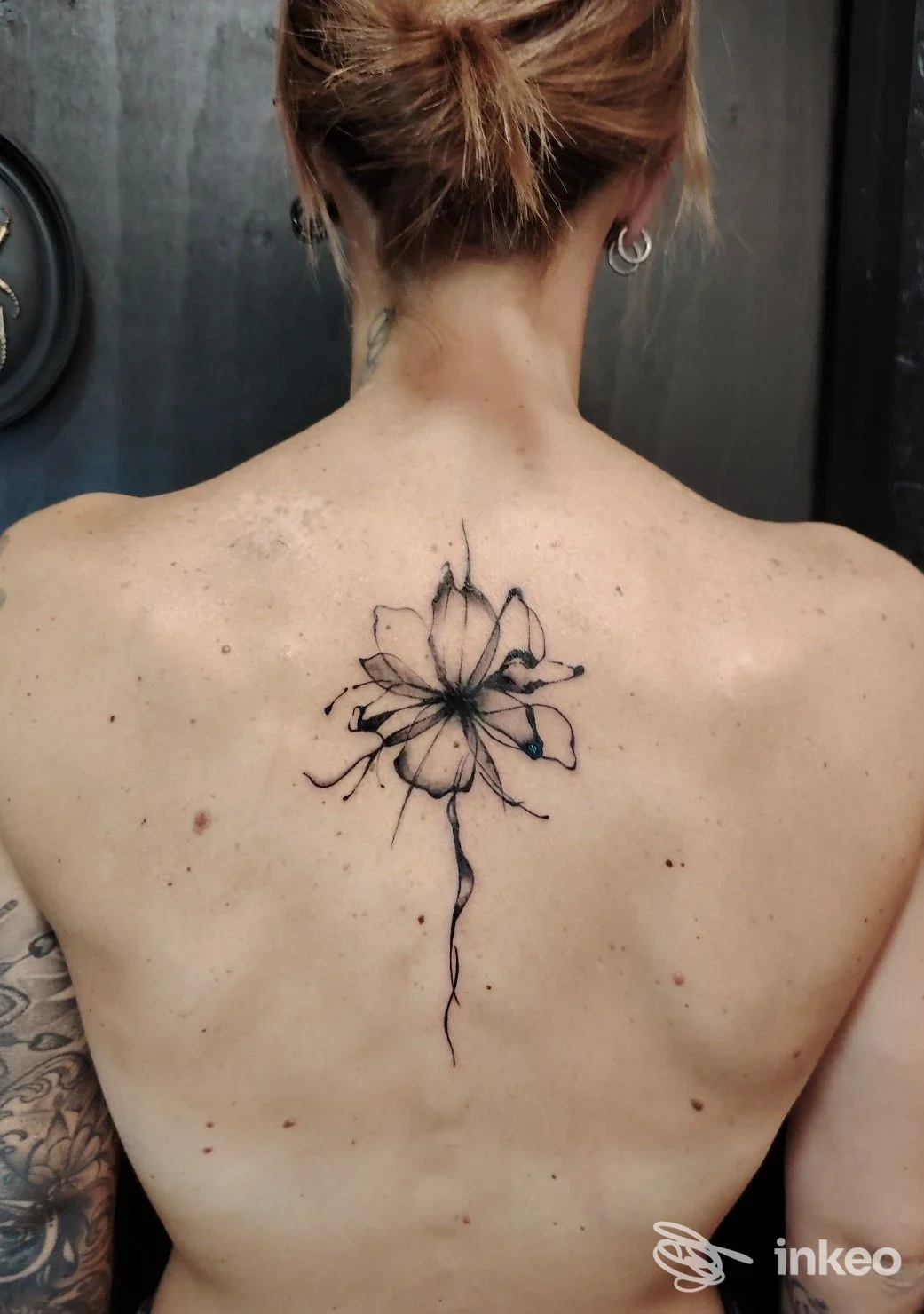 Tatuaggio floreale nero al centro della parte superiore della schiena, foto scattata presso Velvet Drop Tattoo Boutique, Trevignano.