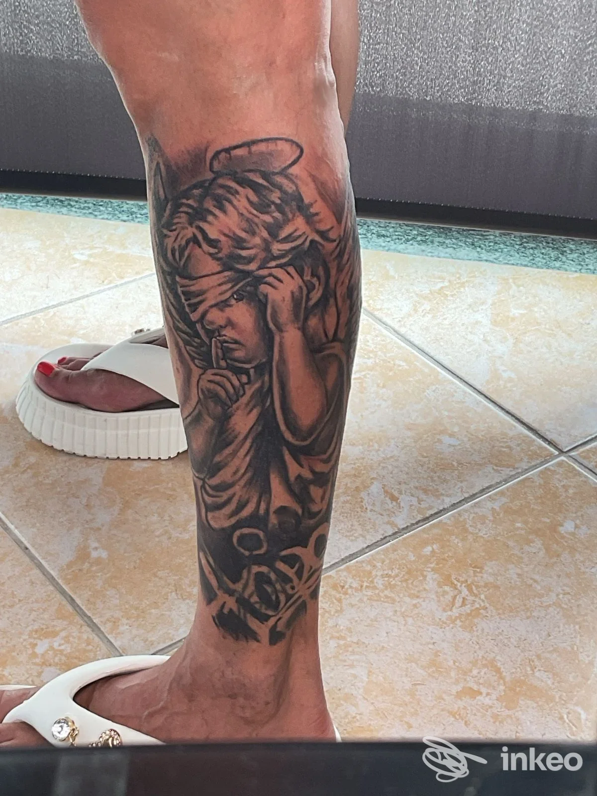 Tatuaggio black & grey raffigurante angelo bendato sul polpaccio, foto inviata da Seven Tattoo studio, Ostuni.