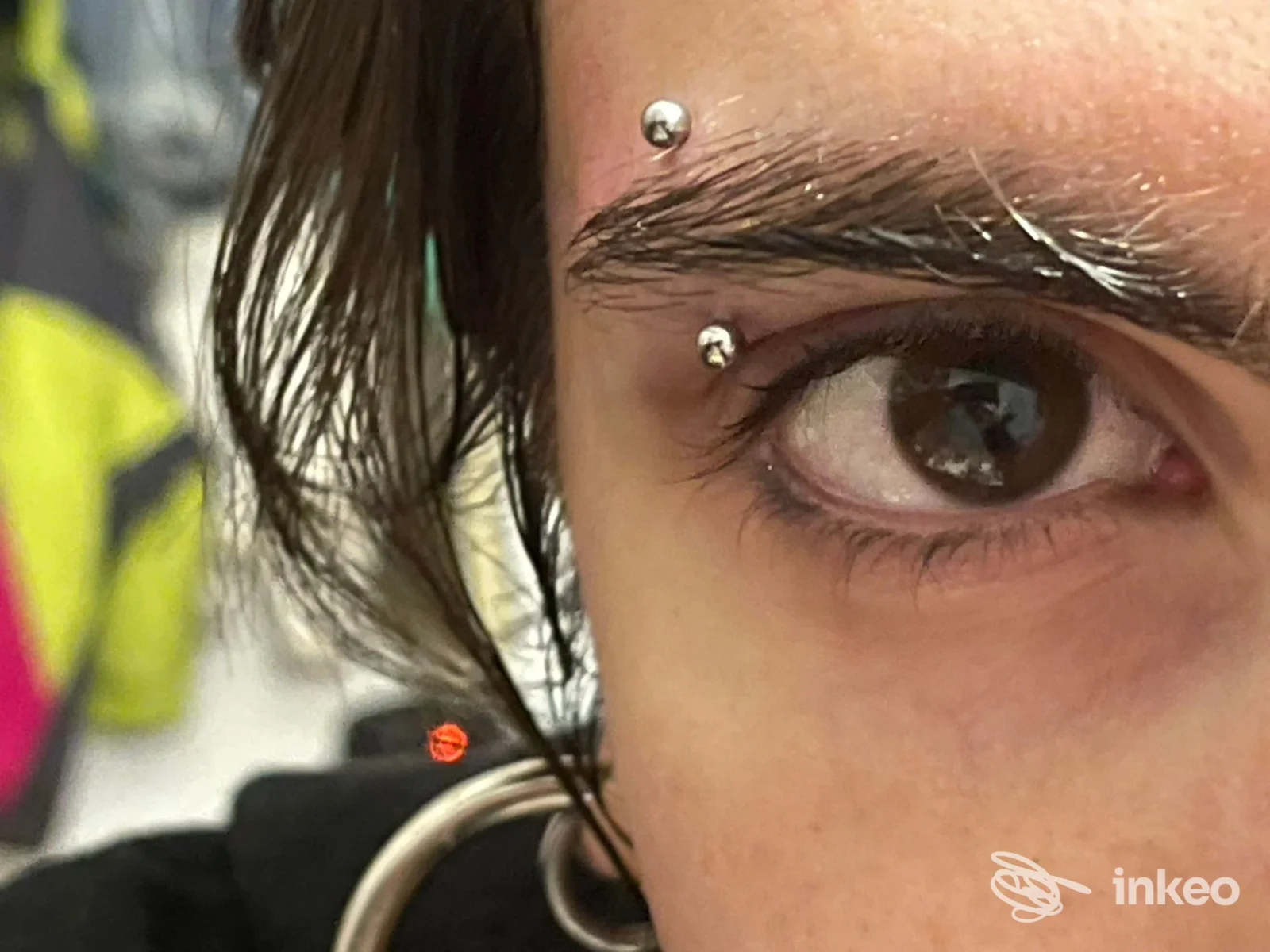 Primo piano di un piercing al sopracciglio eseguito da Scorpion Space a Bologna, dettaglio sull'arcata sopraccigliare e pelle circostante.