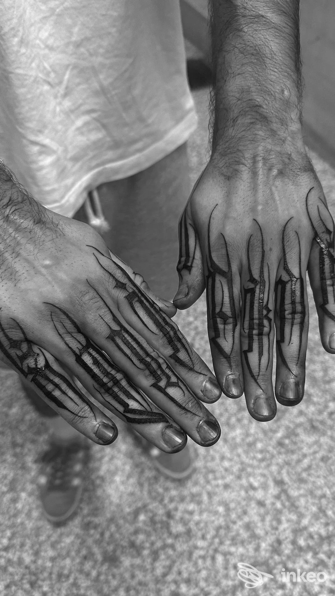 Due mani tatuate con linee nere sul dorso e sulle dita, foto di lavoro eseguito da Ale Guasto Dark Lettering a Bologna.