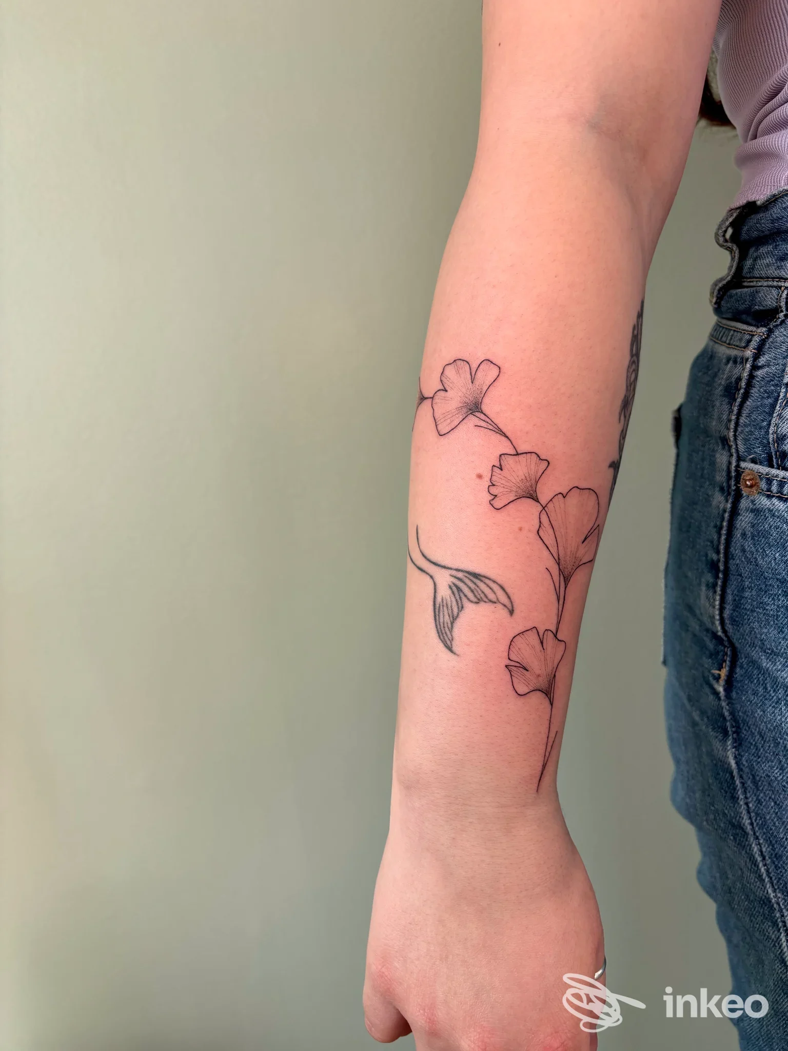 Avambraccio tatuato con motivo floreale a linee sottili, foto condivisa dallo studio MiniBi Tattoo a Modena.
