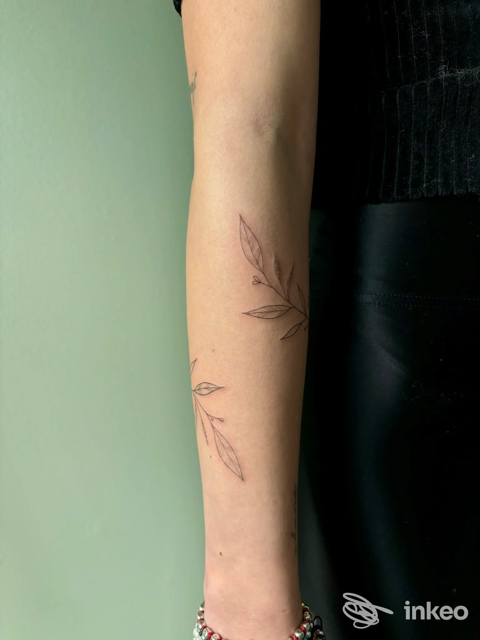 Sottile tatuaggio botanico a linee nere sull'avambraccio, foto per portfolio MiniBi Tattoo, Modena.