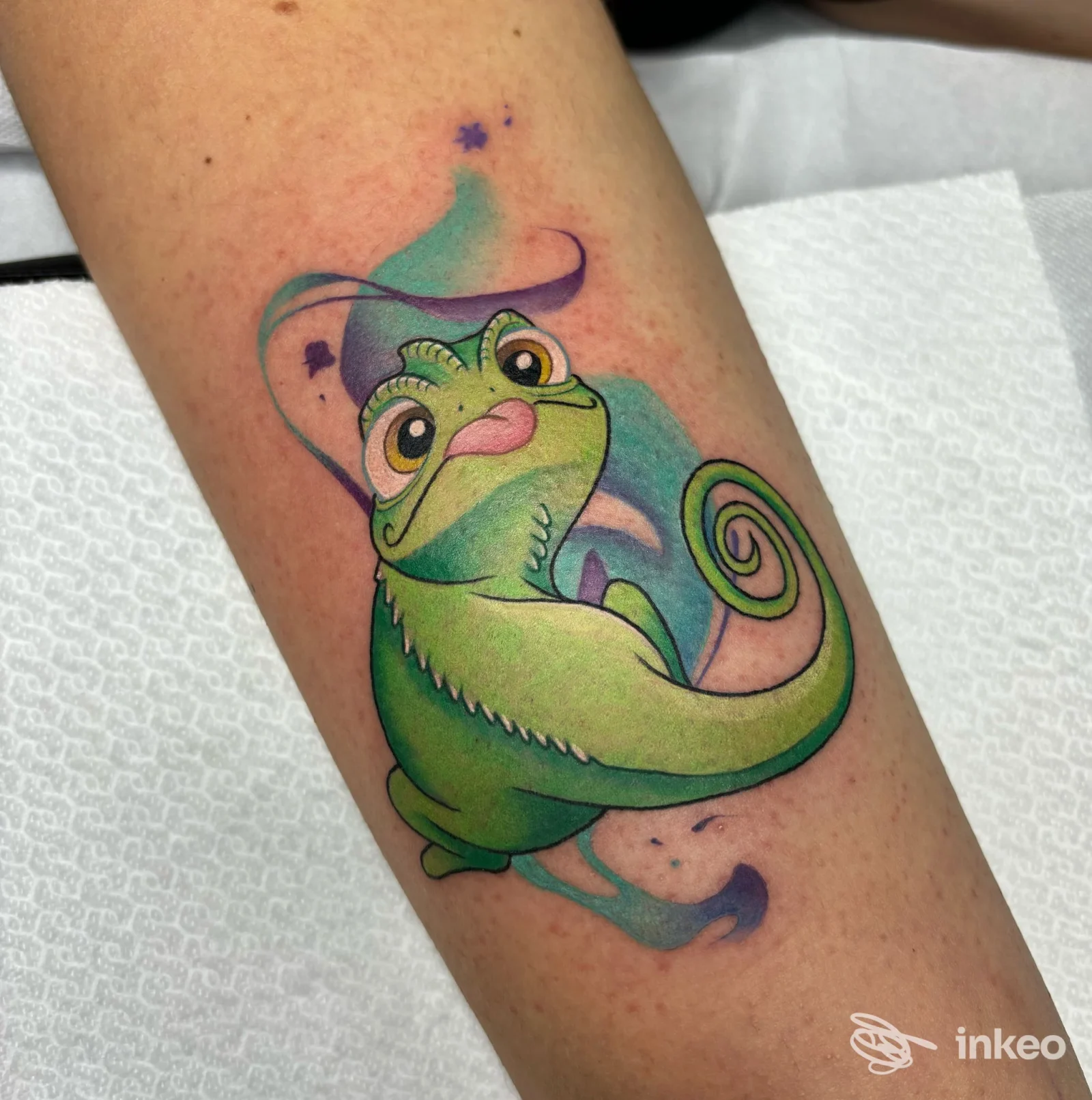 Tatuaggio colorato di camaleonte sull'avambraccio, con sfumature verdi e viola — Electric Tattoo Studio, Asti.