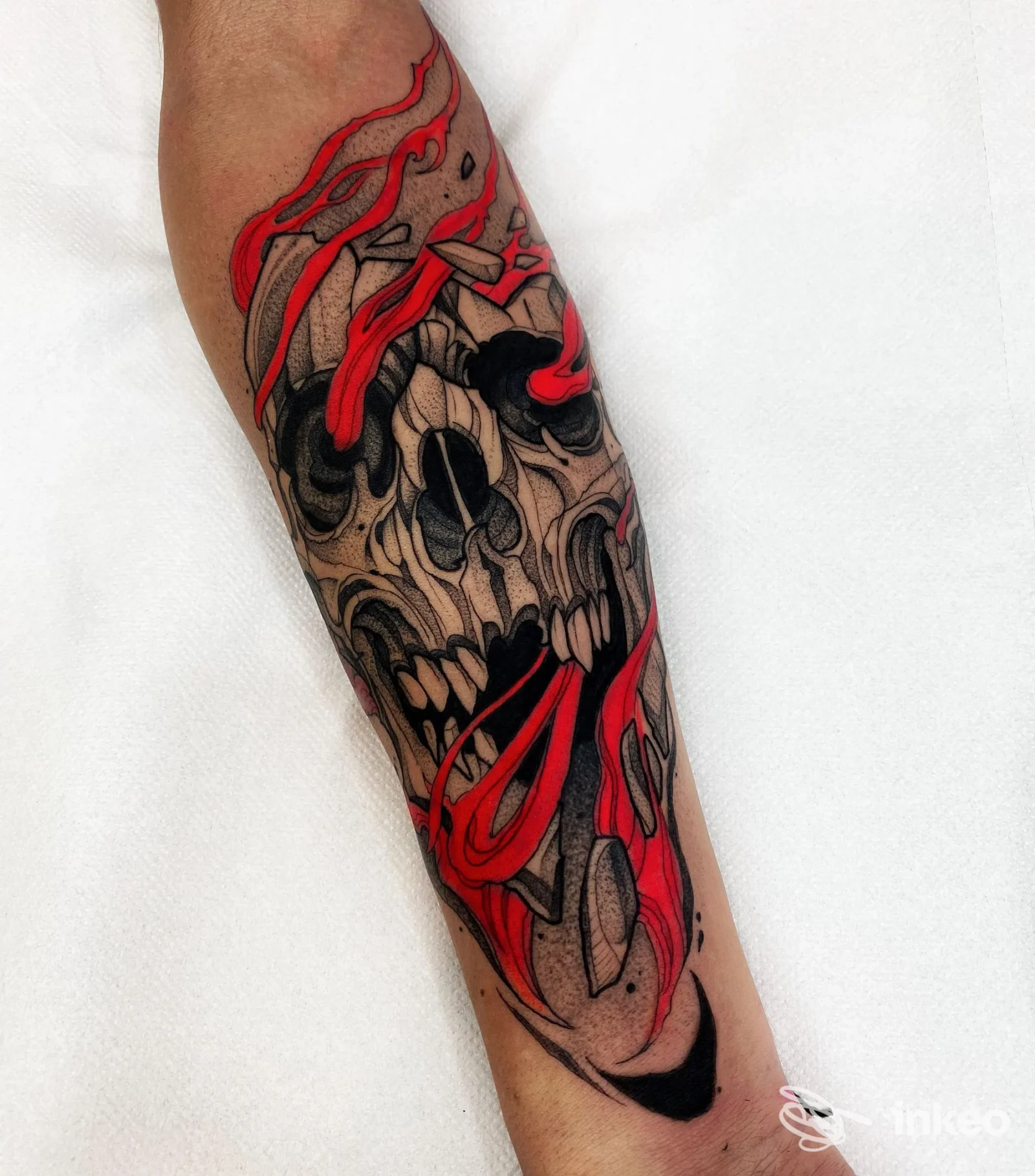 Tatuaggio su avambraccio con teschio stilizzato e fiamme rosse, fotografia promossa da Bianco Studio a Giugliano in Campania.
