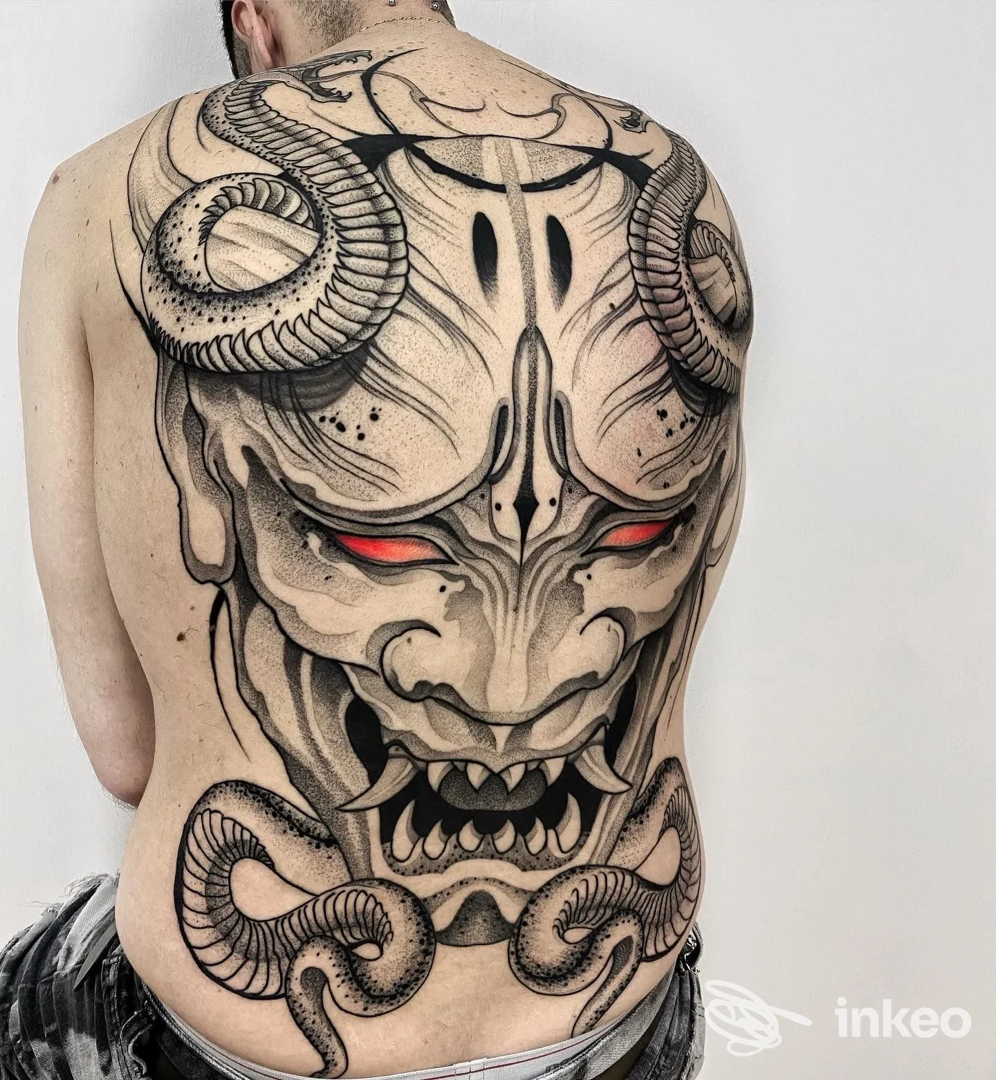 Tatuaggio coprente su tutta la schiena: grande volto demoniaco stilizzato con corna e occhi rossi, Bianco Studio, Giugliano in Campania.